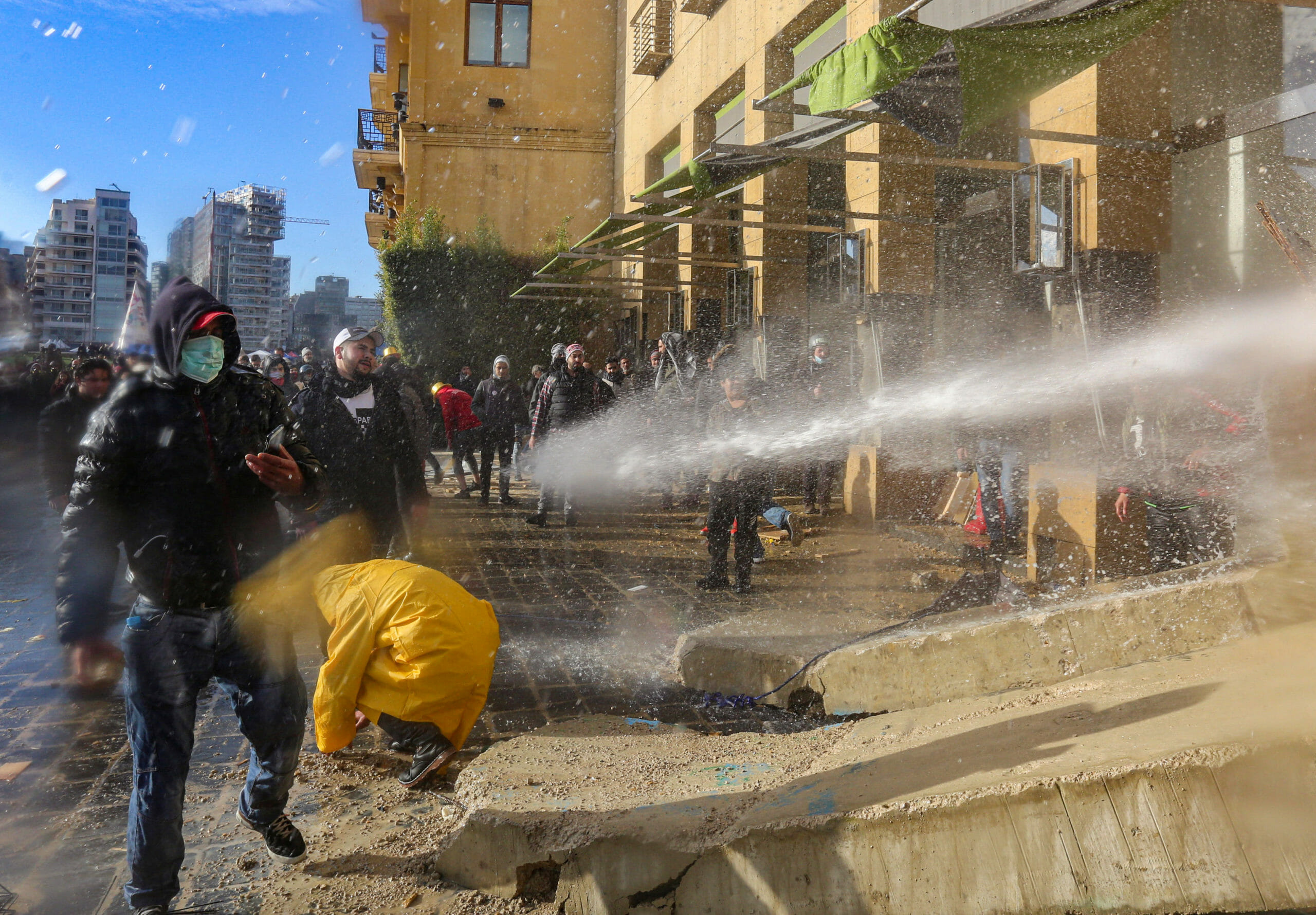 Demonstrators are sprayed with a water cannon during a protest seeking to prevent MPs and government officials from reaching the parliament for a vote of confidence, in Beirut, Lebanon February 11, 2020. REUTERS