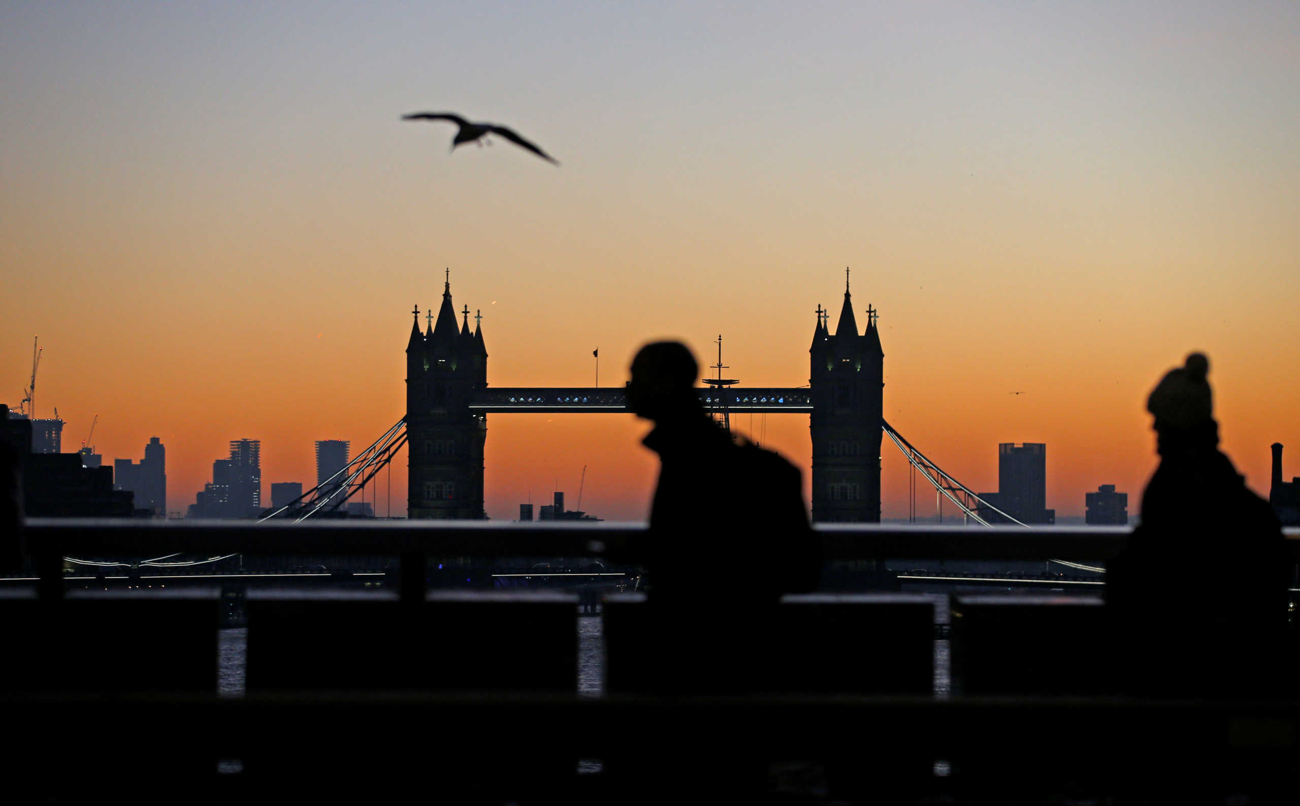 Dawn breaks and silhouettes Tower Bridge and commuters crossing the River Thames in London, Britain, December 13, 2018. REUTERS