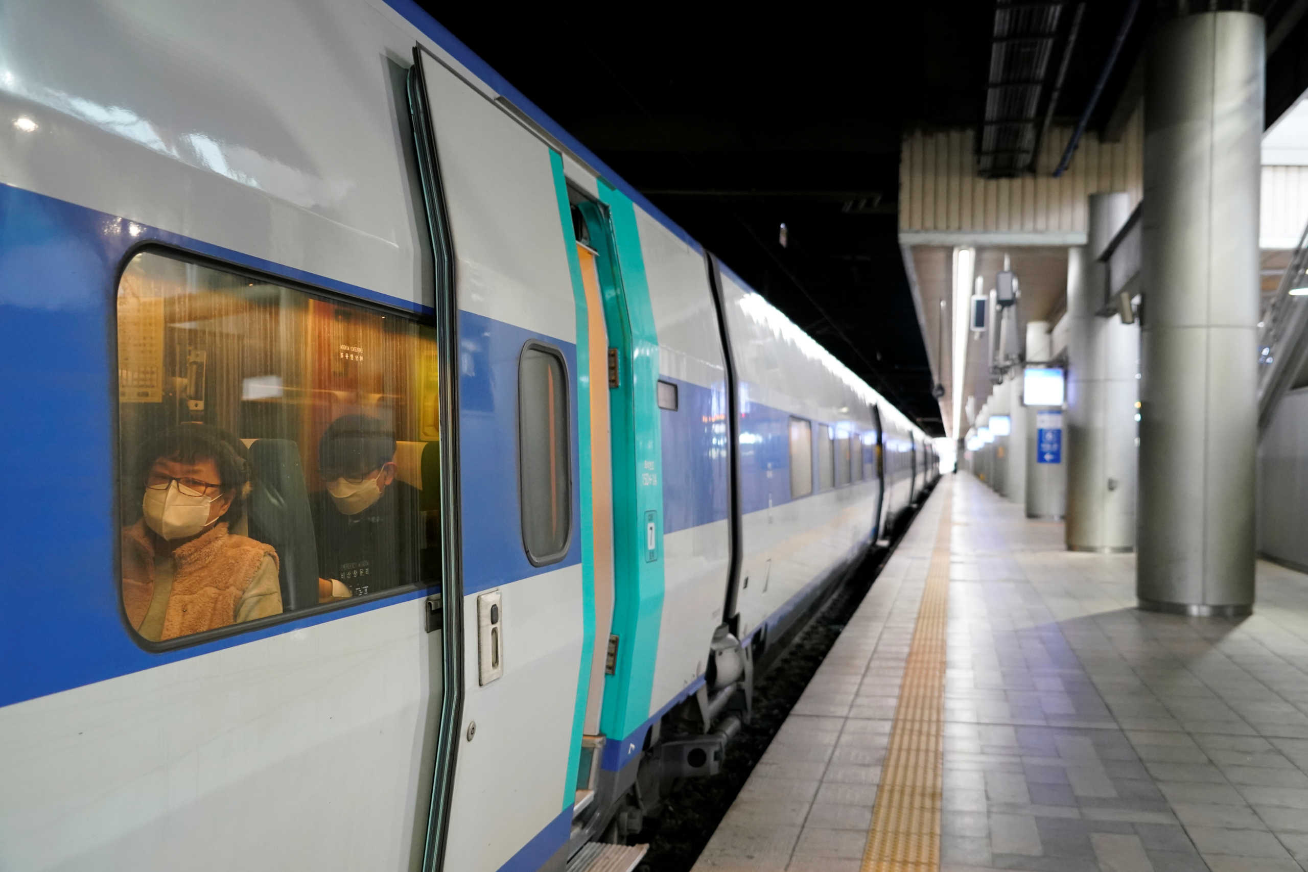 Passengers wearing masks to prevent contacting the coronavirus sit inside a KTX train at Seoul Railway Station in Seoul, South Korea, February 25, 2020.   REUTERS