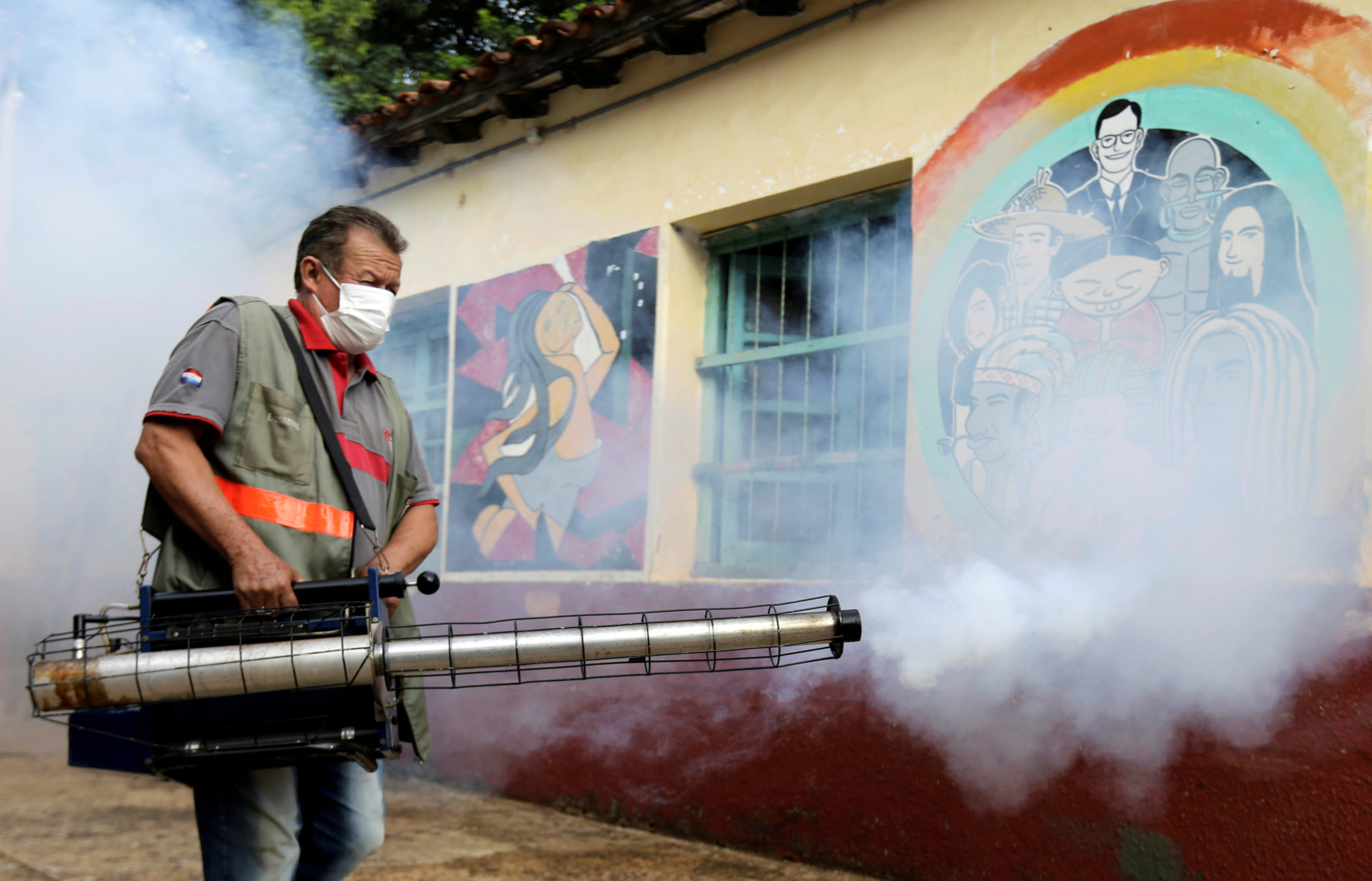 A federal health worker takes part in fumigation to prevent the proliferation of mosquitos that transmit the Dengue fever at the San Lorenzo National School, in a low-income neighbourhood of San Lorenzo, Paraguay February 12, 2020. REUTERS