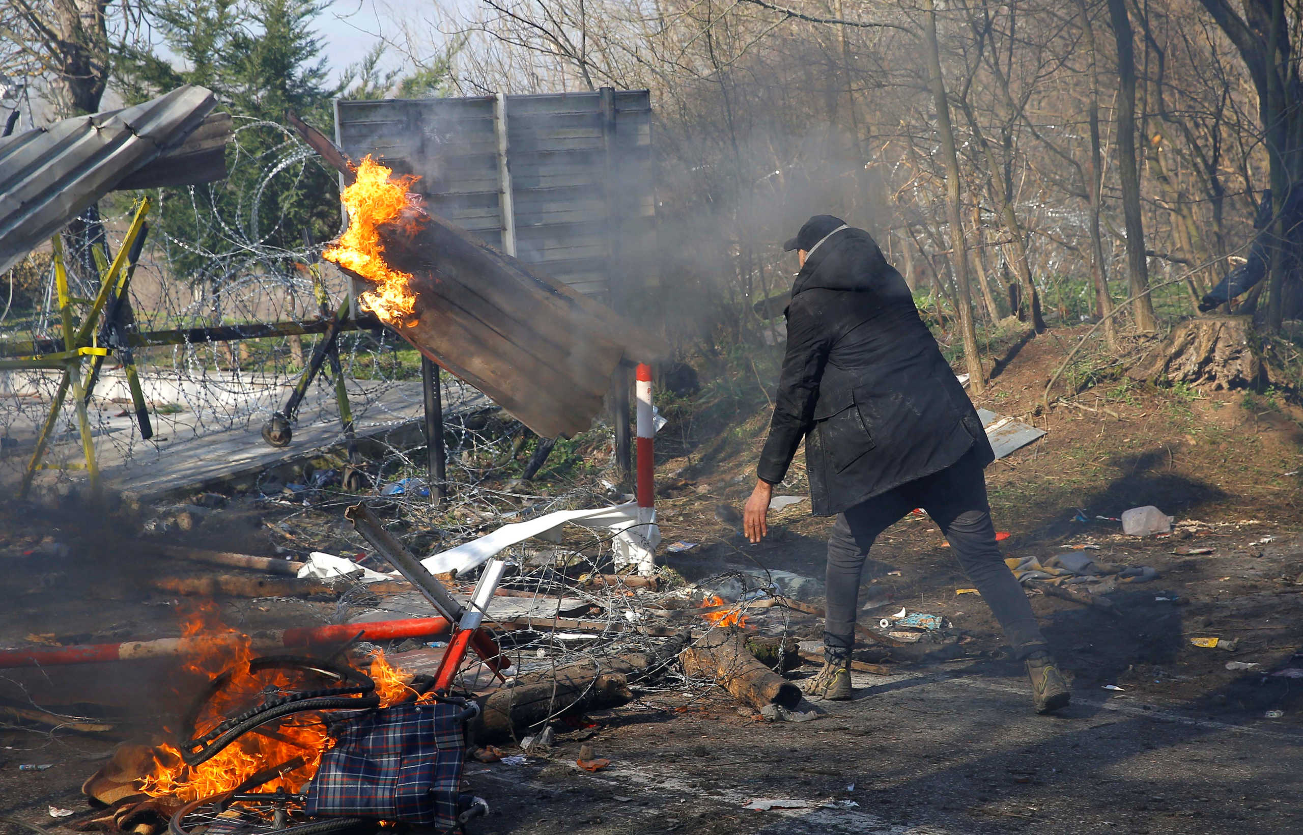 A migrant throws an object at the Turkey's Pazarkule border crossing with Greece's Kastanies, in Edirne, Turkey, February 29, 2020. REUTERS