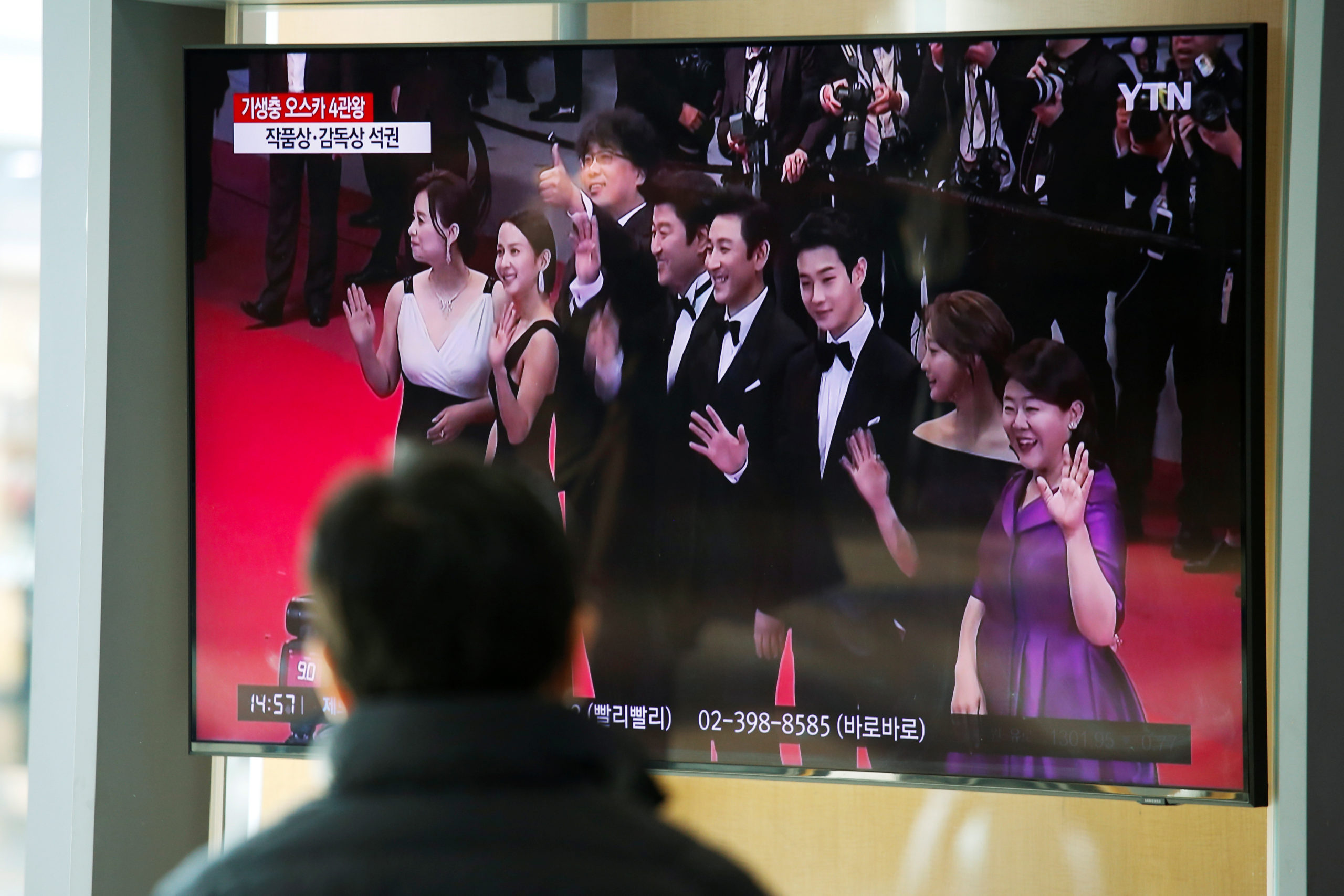 A man watches a TV broadcasting a news report on South Korean director Bong Joon-ho who won four Oscars with his film "Parasite", in Seoul, South Korea, February 10, 2020.   REUTERS