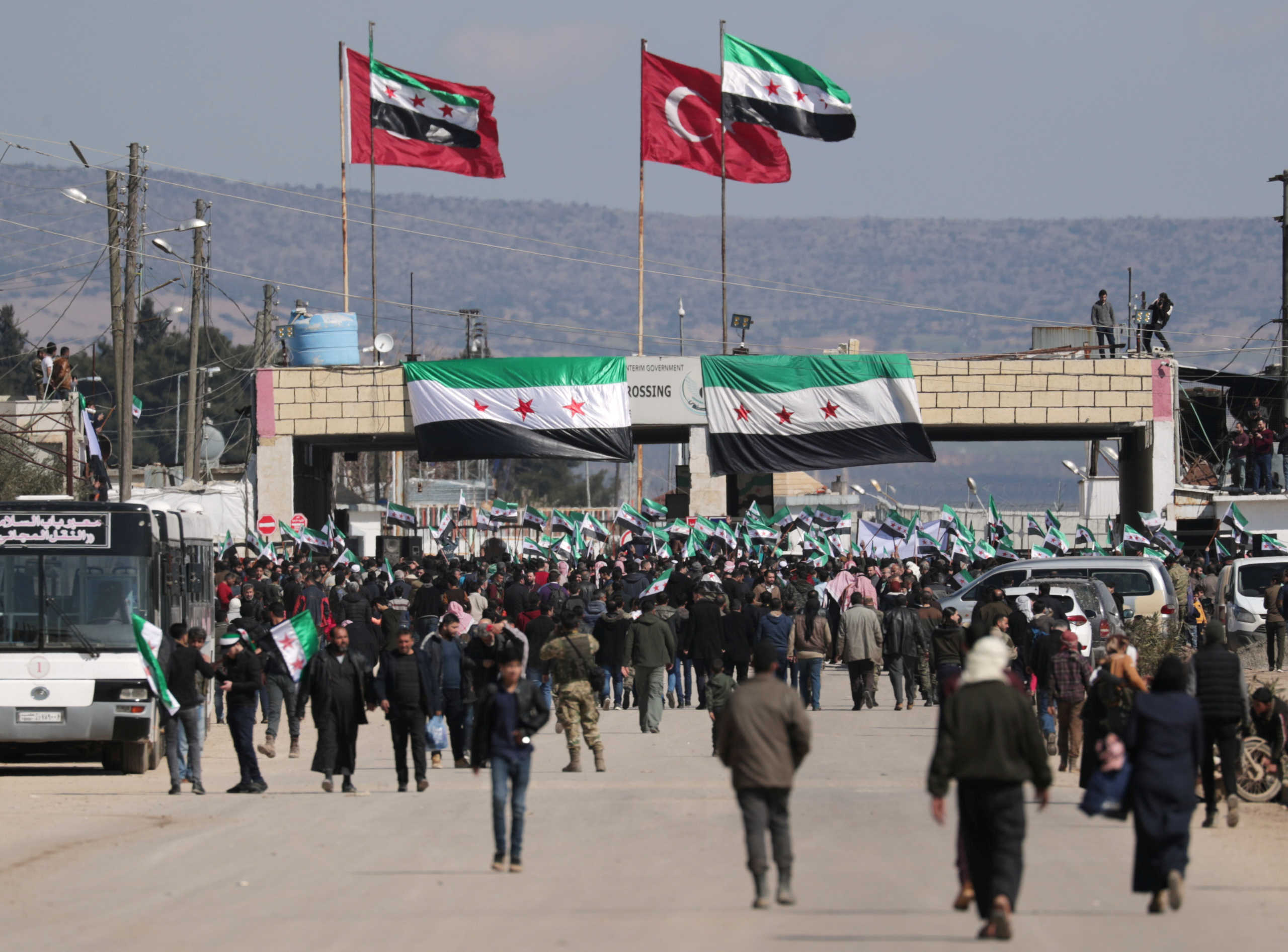 Internally displaced Syrians hold Syrian opposition flags during a protest in support of the Turkish army and Turkey backed Syrian rebels at the Bab el-Salam border crossing between the Syrian town of Azaz and the Turkish town of Kilis, in Syria, February 25, 2020. REUTERS