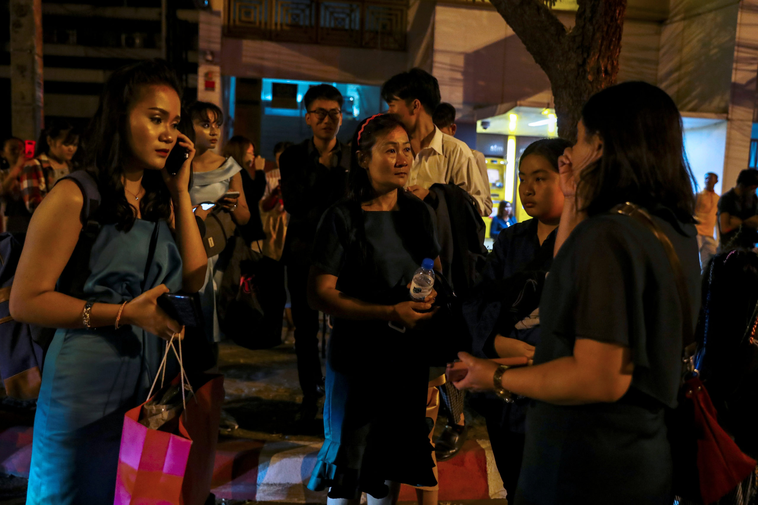 People who were evacuated from a shopping mall speak to each other after a mass shooting at the Terminal 21, in Nakhon Ratchasima, Thailand February 9, 2020. REUTERS