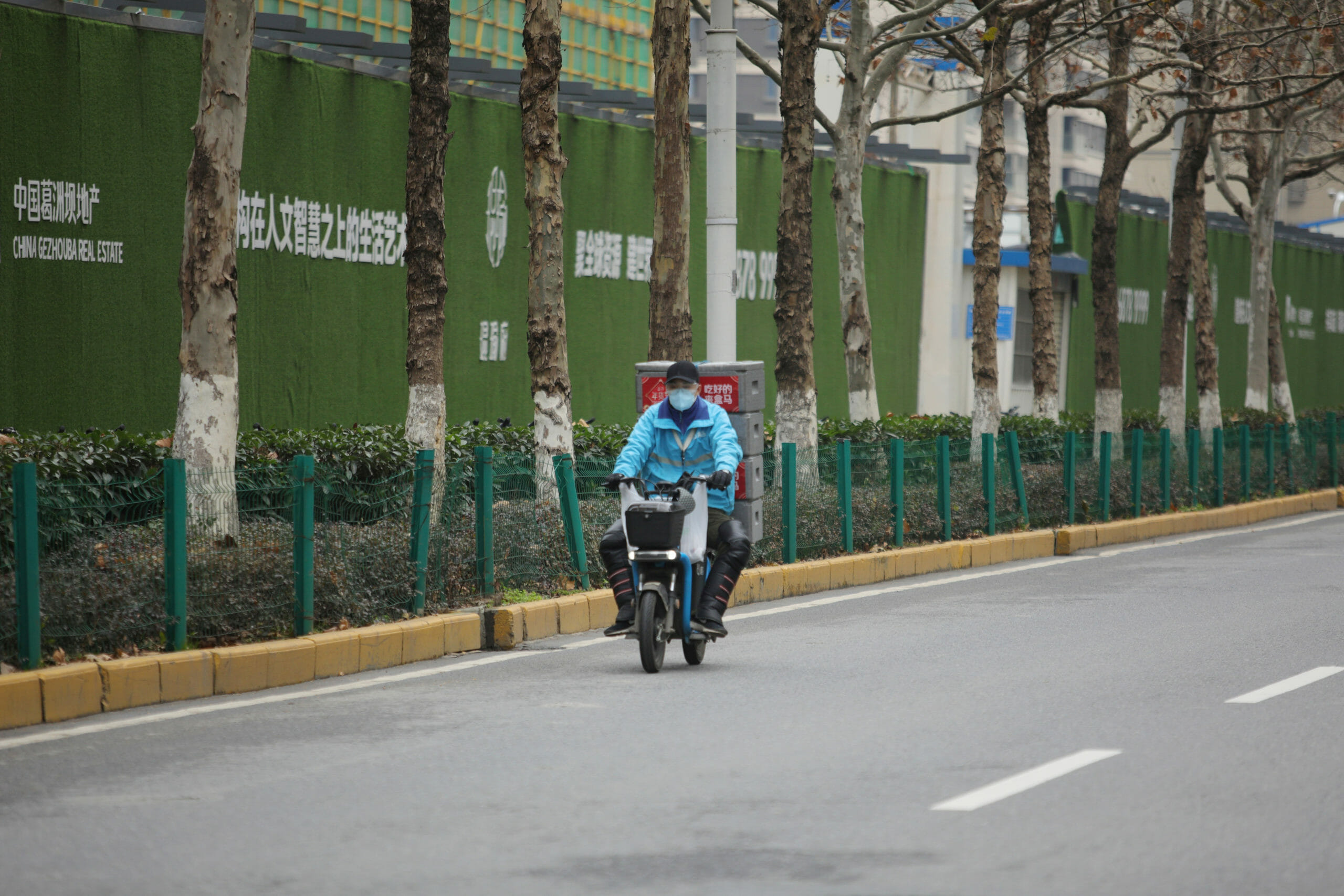 A delivery worker for Alibaba's Hema Fresh supermarket chain rides an electric bike following an outbreak of the novel coronavirus in Wuhan, Hubei province, China February 11, 2020.  REUTERS