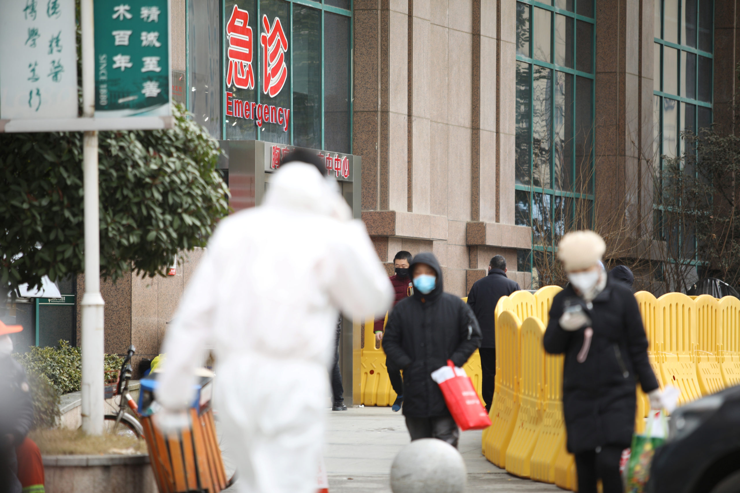 People wearing face masks walk outside the Central Hospital of Wuhan following an outbreak of the novel coronavirus in Wuhan,  in Hubei province, China February 7, 2020. REUTERS