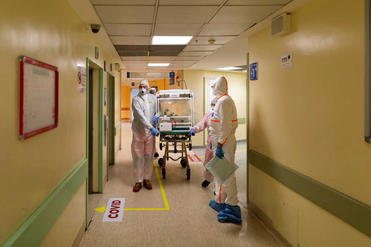 A coronavirus patient arrives on a stretcher at the Columbus Covid Hospital, which has been assigned as one of the new coronavirus treatment hospitals in Rome, after being transferred by medical workers in protective white suits from the Gemelli Hospital, in Rome, Italy, March 16, 2020. Picture taken March 16, 2020. Policlinico Gemelli