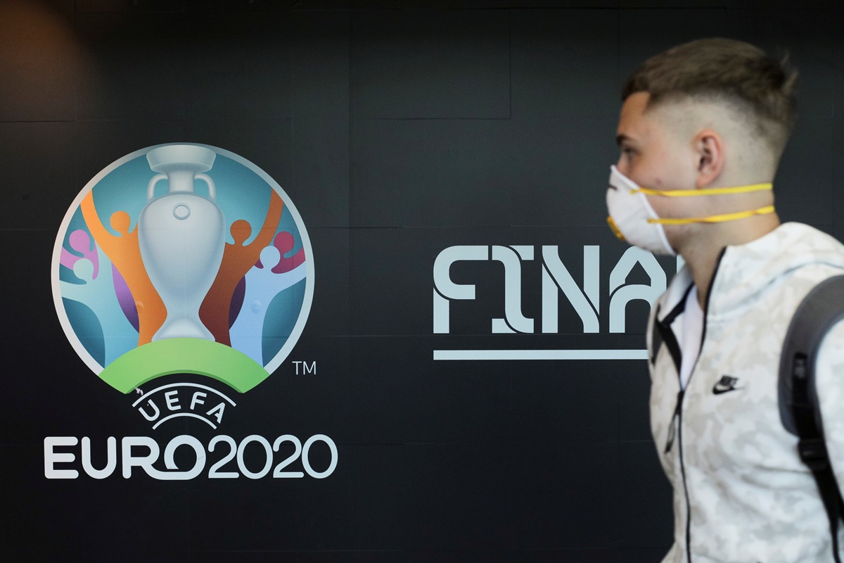 Travellers pass by a logo of the 2020 UEFA European Football Championship displayed on a wall inside Bucharest Henri Coanda International Airport, in Otopeni, Romania, March 16, 2020. Inquam Photos