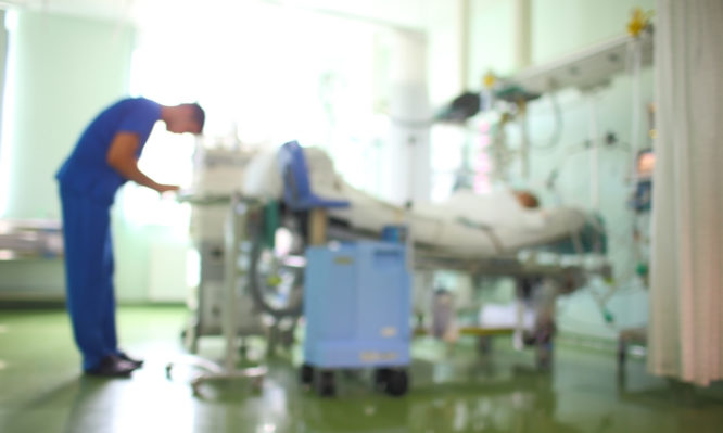 Doctor in the patient ward, unfocused background.