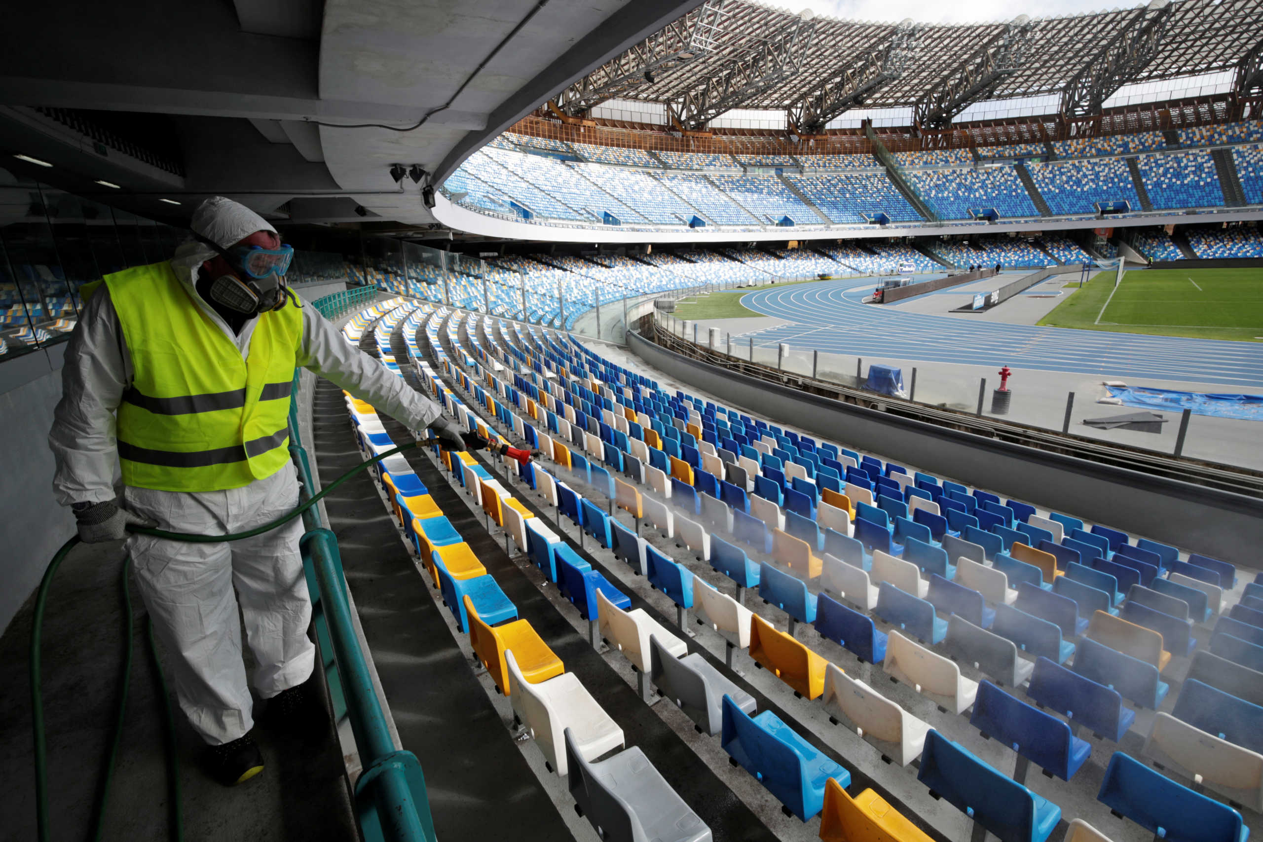 A cleaner wearing a protective suit sanitises seats at the San Paolo stadium ahead of the second leg of the Coppa Italia semi-final between Napoli and Inter Milan, which has since been postponed as part of measures to contain the coronavirus outbreak, in Naples, Italy, March 4, 2020. REUTERS