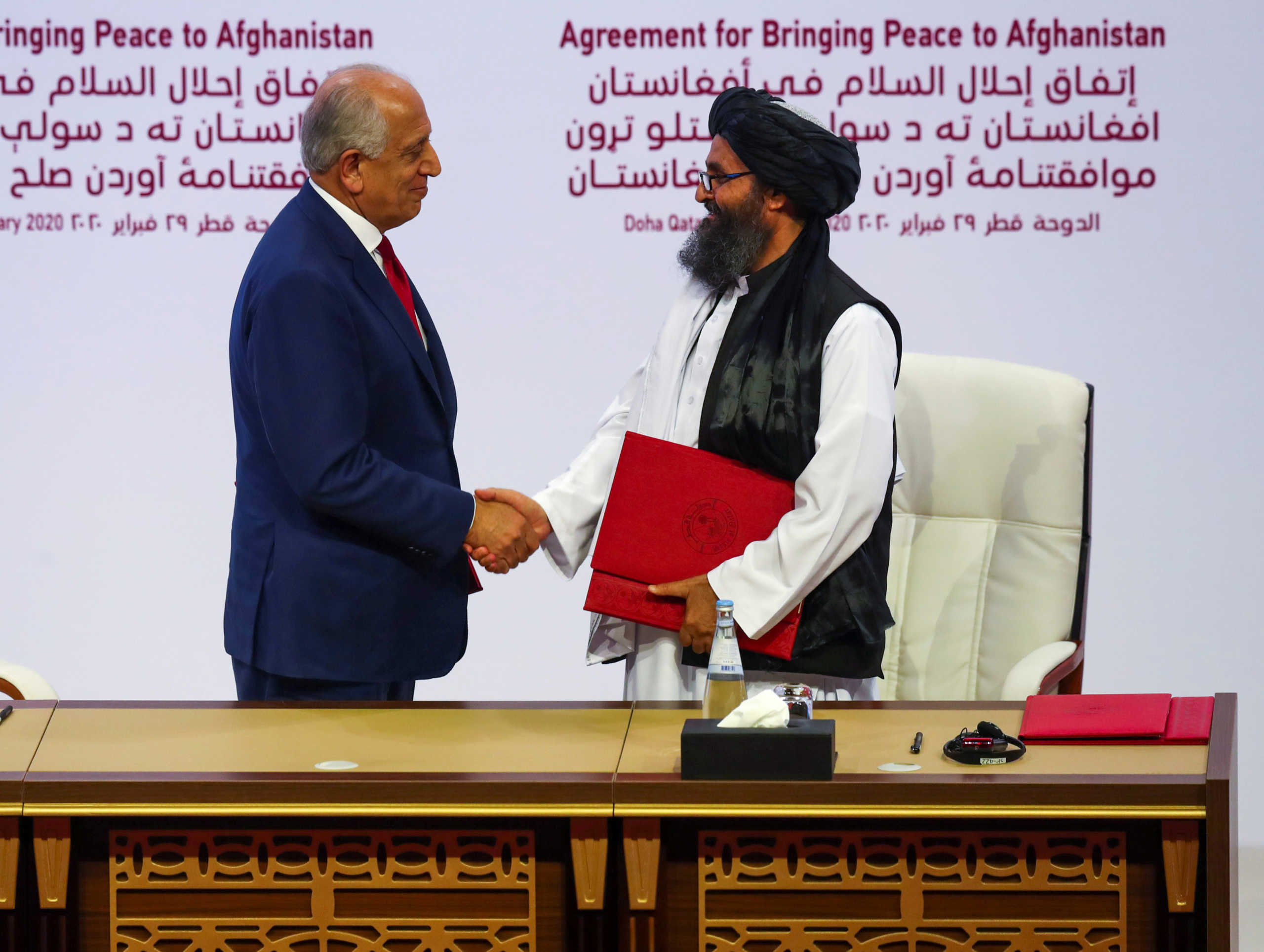 Mullah Abdul Ghani Baradar, the leader of the Taliban delegation, and Zalmay Khalilzad, U.S. envoy for peace in Afghanistan, shake hands after signing an agreement at a ceremony between members of Afghanistan's Taliban and the U.S. in Doha, Qatar February 29, 2020. REUTERS
