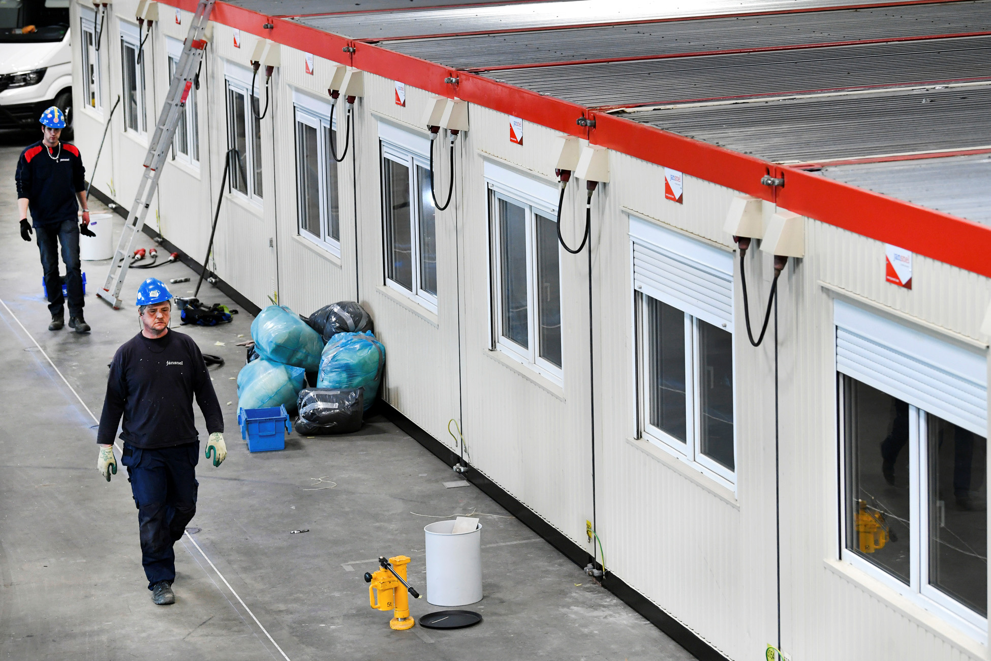 Workers walk near units inside the concert hall Ahoy, that should have hosted the Eurovision song contest in May, and now is used as an emergency hospital, as the spread of coronavirus disease (COVID-19) continues, in Rotterdam, Netherlands March 30, 2020. REUTERS