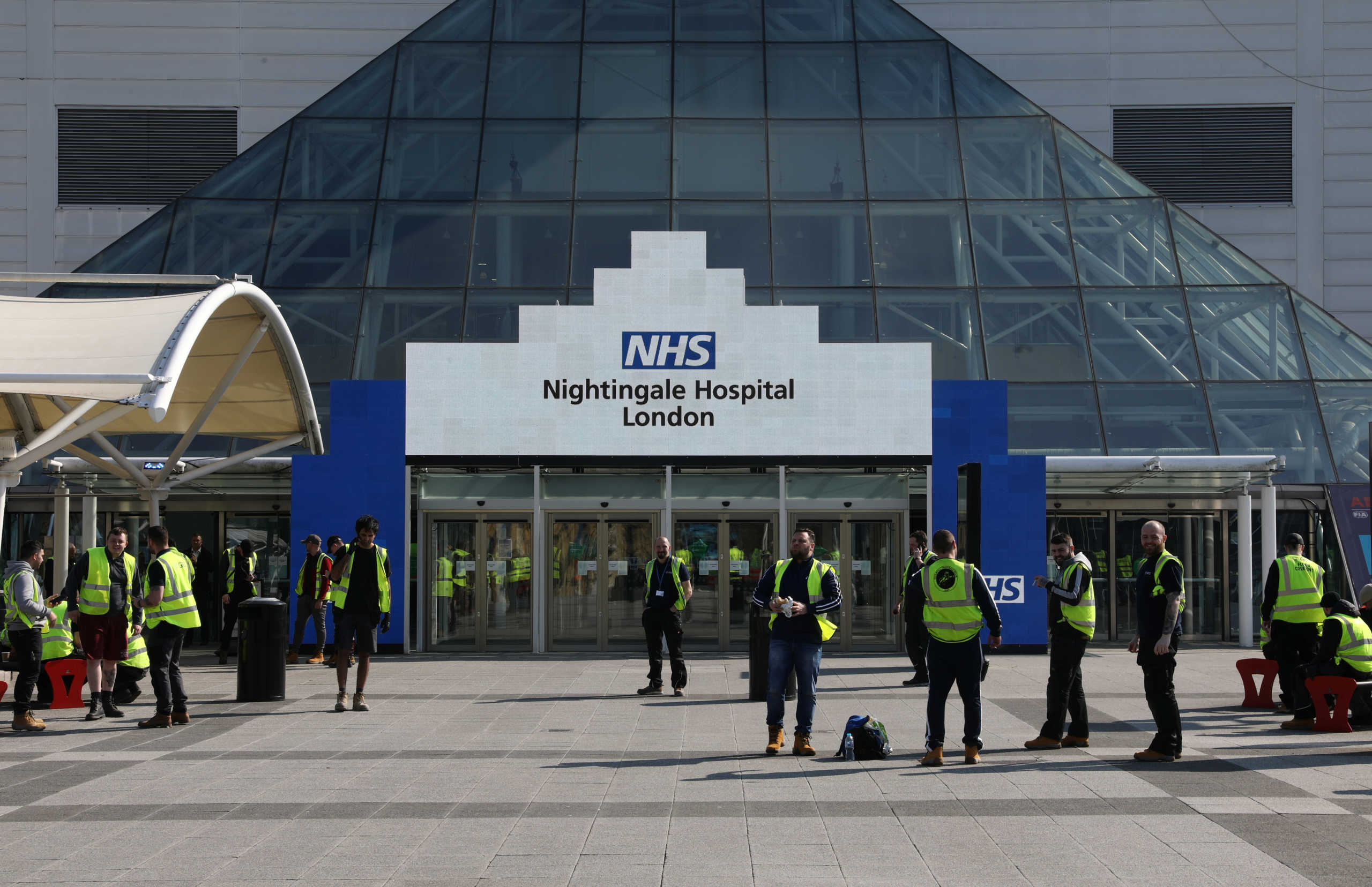 Workers are pictured outside the Excel Centre, London while it is being prepared to become the NHS Nightingale Hospital as the spread of the coronavirus disease (COVID-19) continues, in East London, Britain, March 27, 2020. REUTERS