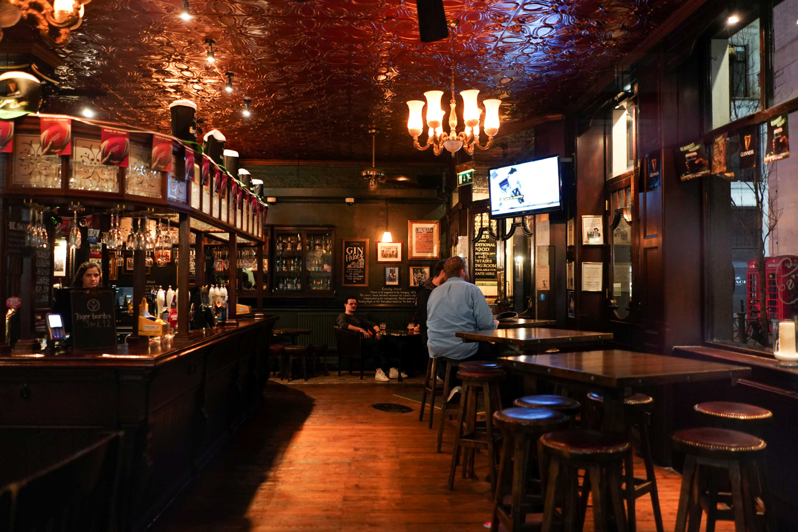 FILE PHOTO: People drink inside a quiet Irish pub in Soho, as the number of coronavirus (COVID-19) cases grow around the world, in London, Britain, March 17, 2020. REUTERS