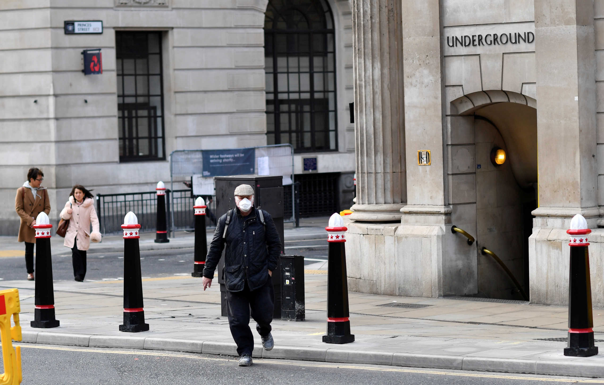 A man wears a protective face mask while walking through a deserted avenue, as the spread of the coronavirus disease (COVID-19) continues, in London, Britain, March 20, 2020. REUTERS