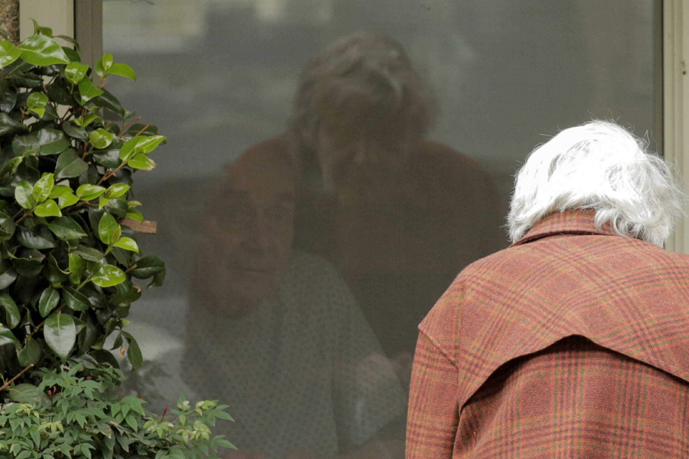 Gene Campbell talks through a window with his wife of more than 60 years, Dorothy Campbell, at the Life Care Center of Kirkland, the long-term care facility linked to several confirmed coronavirus cases in the state, in Kirkland, Washington, U.S. March 5, 2020.  REUTERS