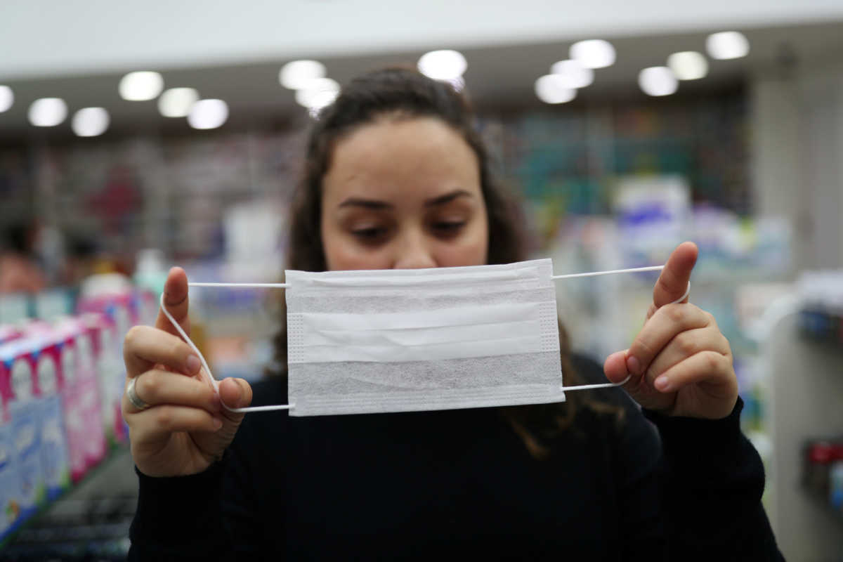 A vendor displays a protective mask at a pharmacy, after the second case of coronavirus in Sao Paulo was confirmed, at Guarulhos International Airport in Guarulhos, Sao Paulo state, Brazil, February 29, 2020. REUTERS