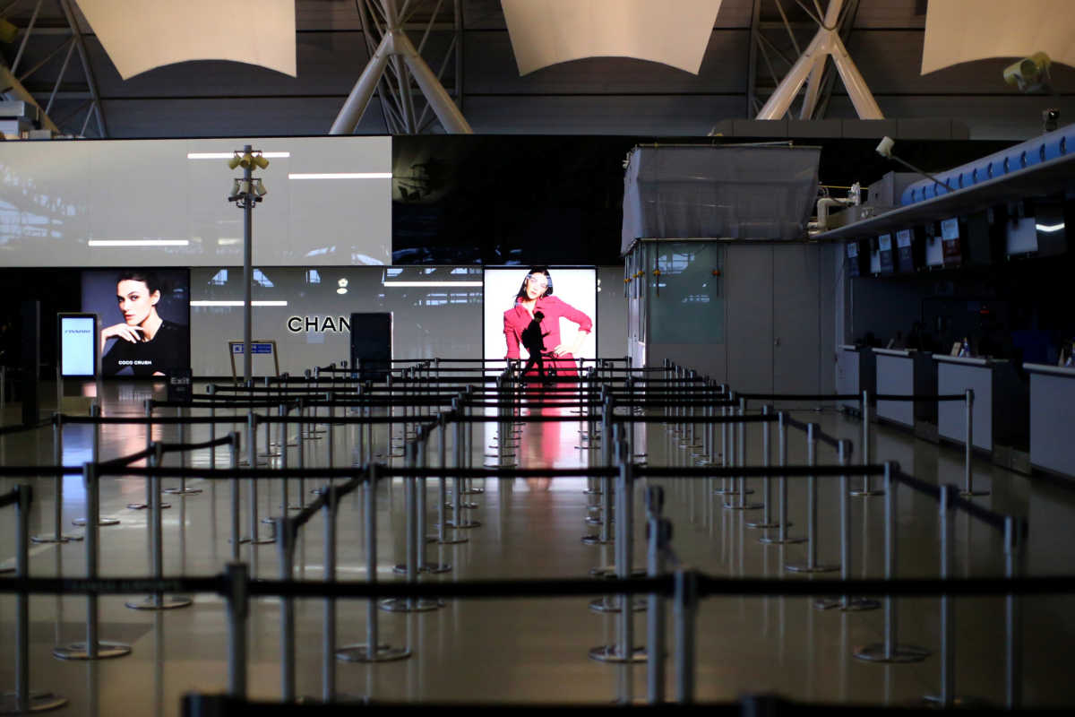 A passenger, wearing protective mask following an outbreak of the coronavirus disease (COVID-19), walks at the almost empty Kansai International Airport in Osaka, Japan, March 14, 2020. REUTERS