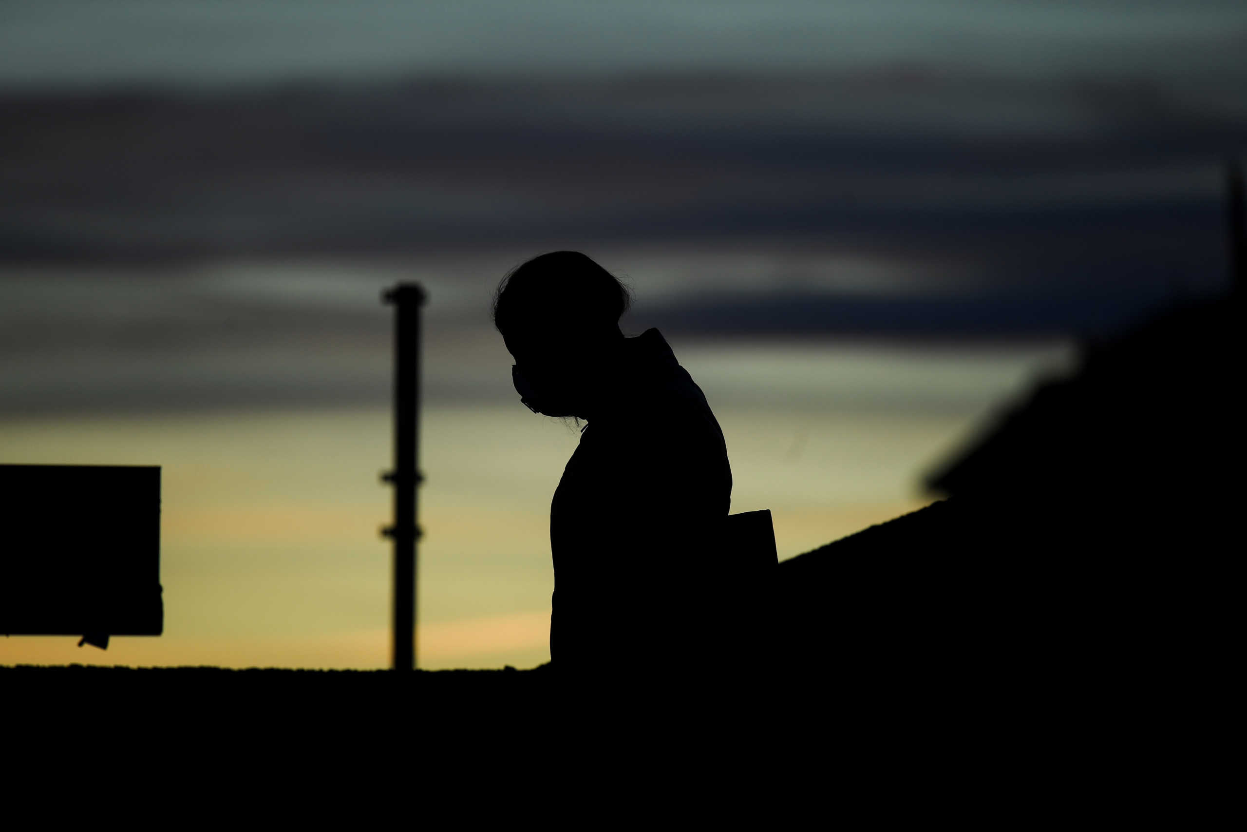 A person wears a protective face mask during sunset in Navigli district, after a decree orders for the whole of Italy to be on lockdown in an unprecedented clampdown aimed at beating the coronavirus,in Milan Italy, March 10, 2020. REUTERS