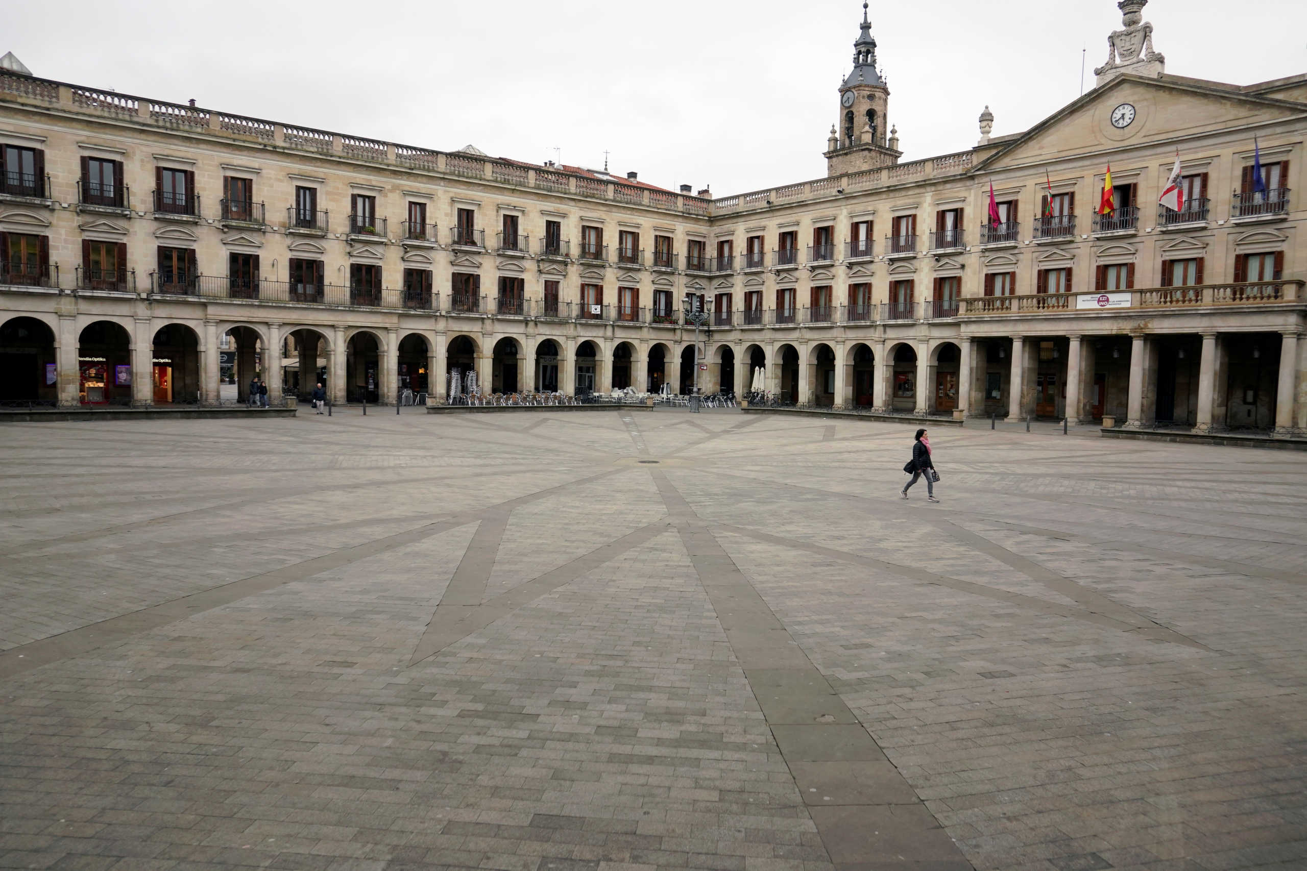 A woman walks across an empty square, amidst concerns over Spain's coronavirus outbreak, in the Basque city of Vitoria, Spain March 12, 2020. REUTERS