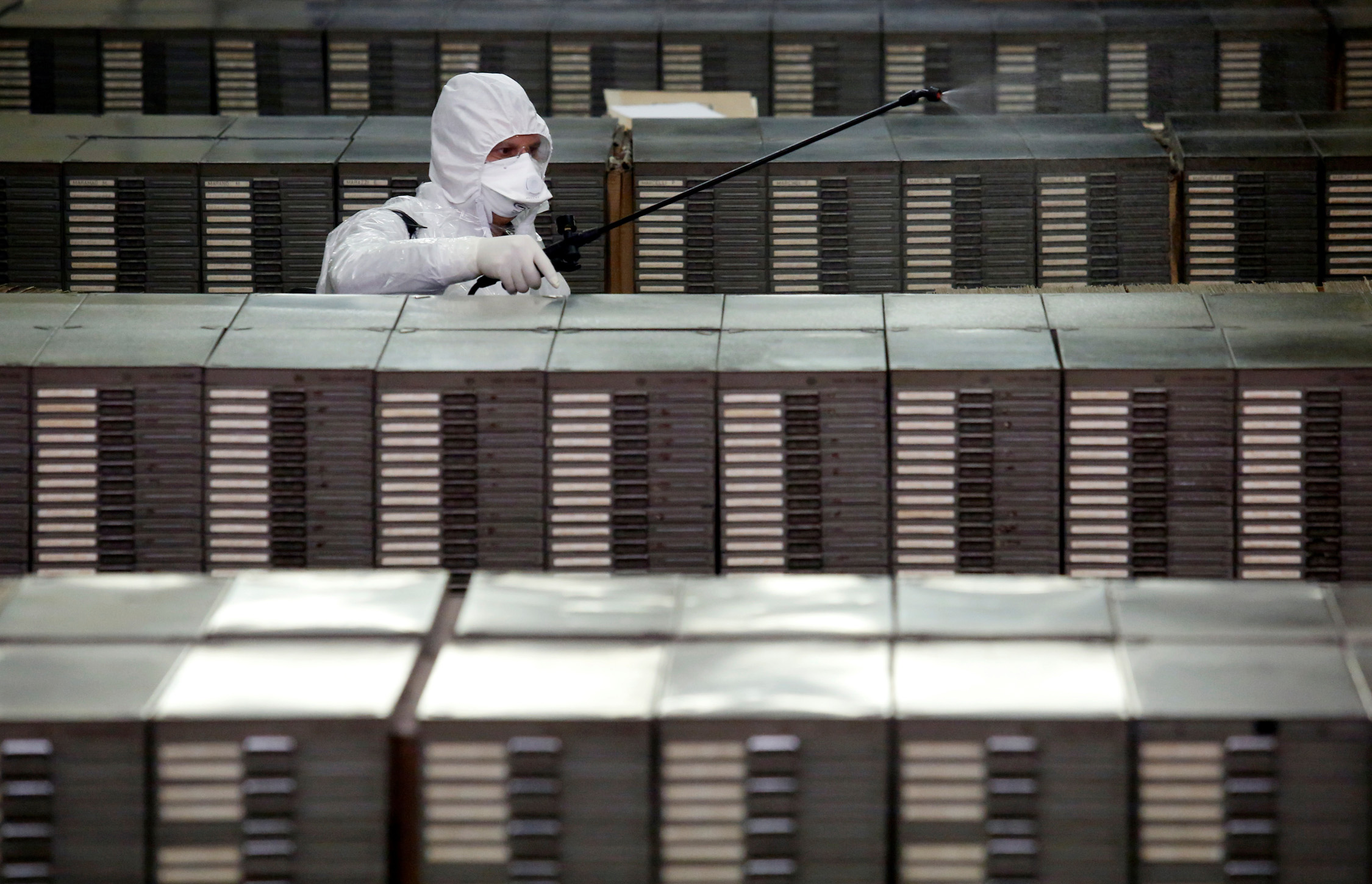 Cleaners sanitize documents inside the archives of Rome's Anagrafe, the city's Registration Office, as the coronavirus disease (COVID-19) spreads, in Rome, Italy, March 27, 2020. REUTERS
