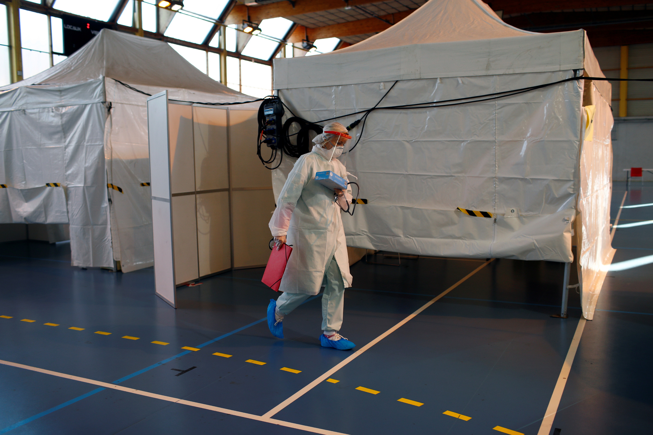 Doctor Caroline Reverdy, wearing protective suit and face mask, works at an emergency COVID-19 center inside a gymnasium in Taverny near Paris as the spread of the coronavirus disease continues in France, March 26, 2020.  REUTERS