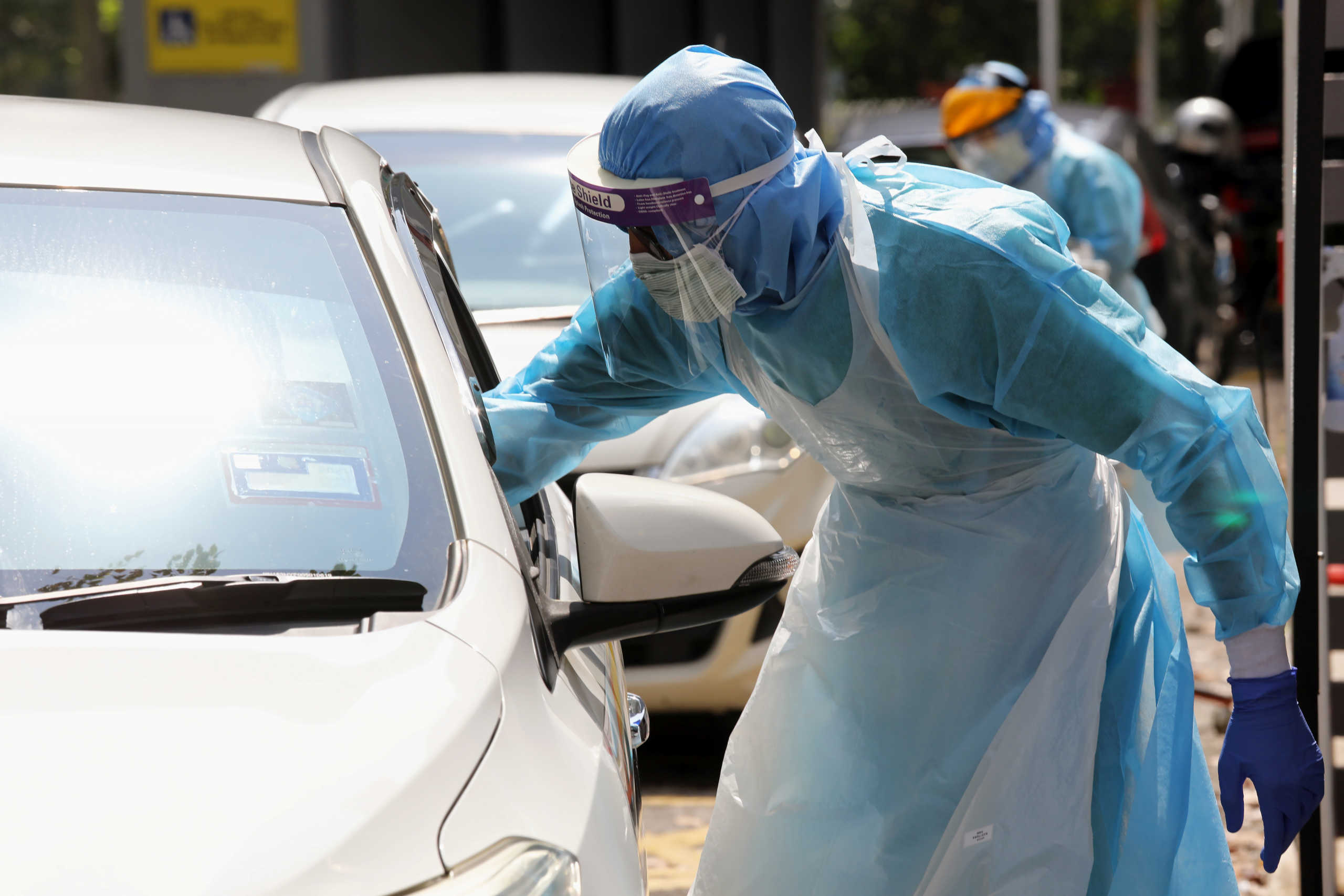 Health workers perform testing at a drive-thru coronavirus disease (COVID-19) testing center at KPJ Damansara Specialist Hospital, in Petaling Jaya, Malaysia March 28, 2020. REUTERS