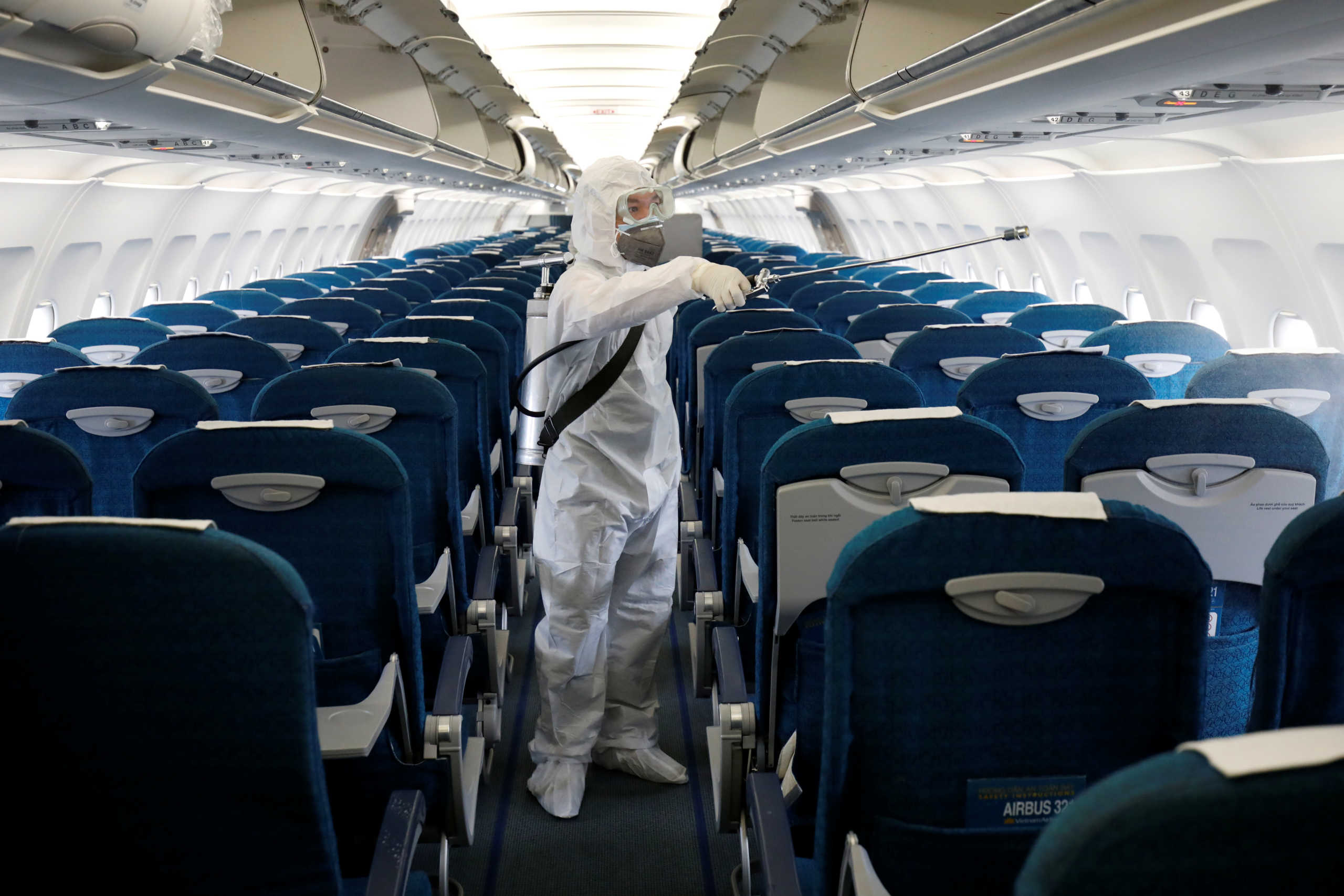 A health worker sprays disinfectant inside a Vietnam Airlines airplane to protect from the recent coronavirus outbreak, at Noi Bai airport in Hanoi, Vietnam February 21, 2020. REUTERS