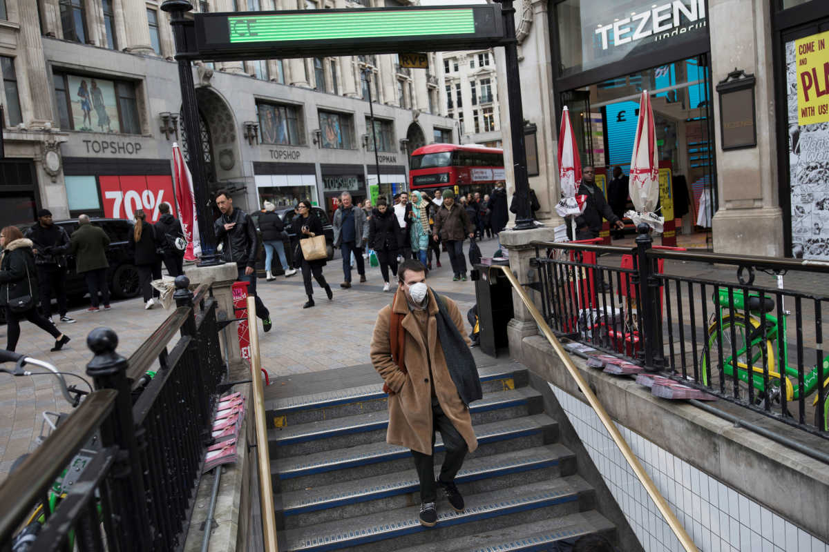 A man wears a protective mask as he walks into Oxford Circus underground station in London, Britain March 13, 2020. REUTERS