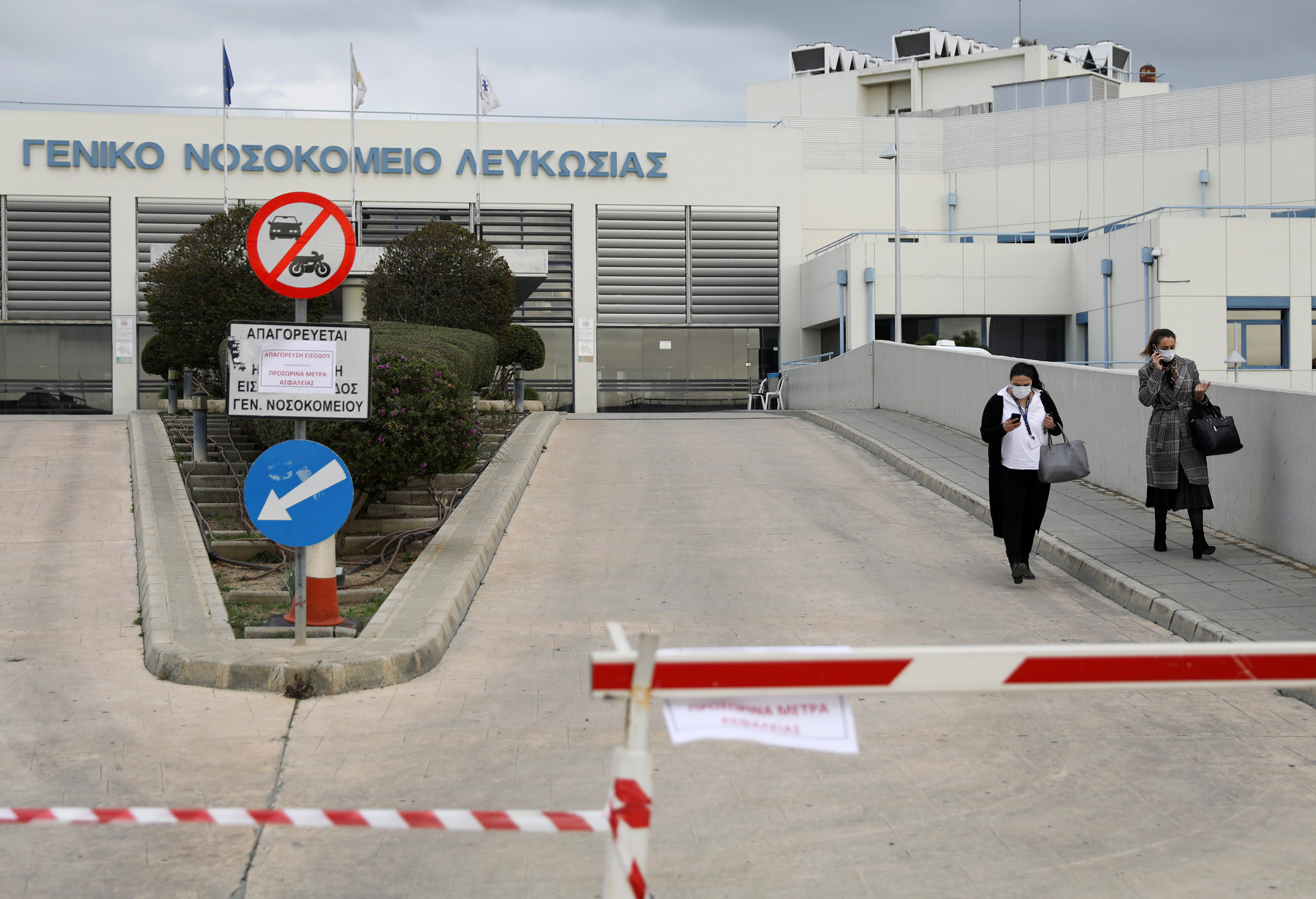 Women wearing masks walk outside Nicosia General hospital, Cyprus's largest medical facility that suspended admissions on Tuesday after a heart surgeon tested positive for coronavirus, in Nicosia, Cyprus March 10, 2020. REUTERS
