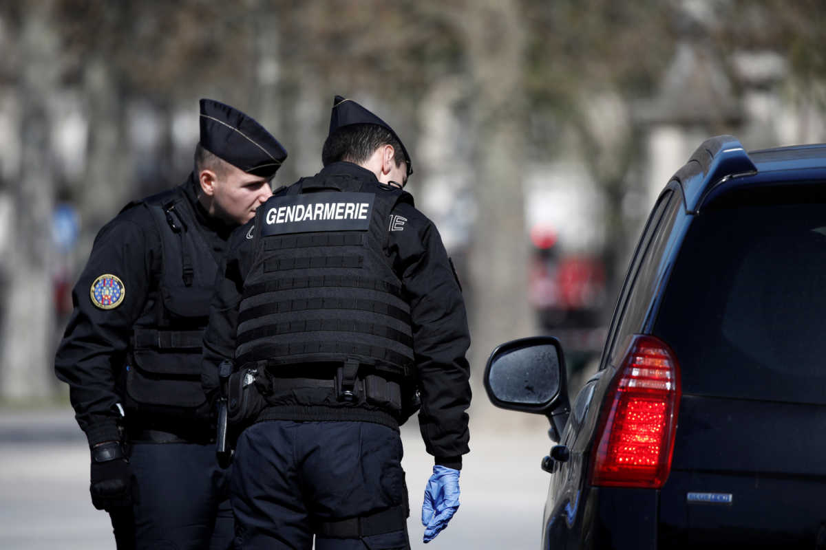 French Gendarmes check a driver in Paris as a lockdown is imposed to slow the rate of the coronavirus disease (COVID-19) spread in France, March 23, 2020. REUTERS