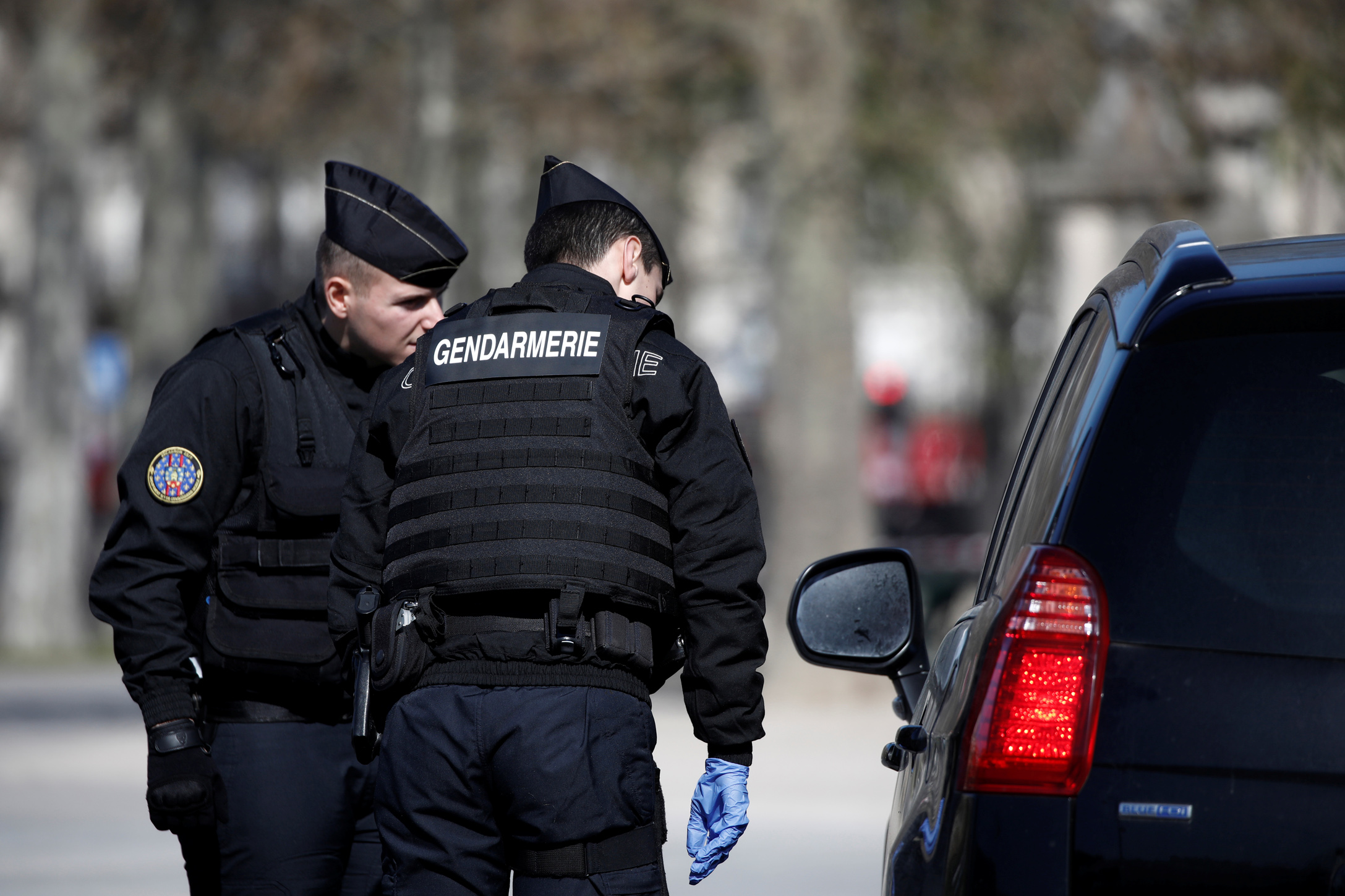 French Gendarmes check a driver in Paris as a lockdown is imposed to slow the rate of the coronavirus disease (COVID-19) spread in France, March 23, 2020. REUTERS