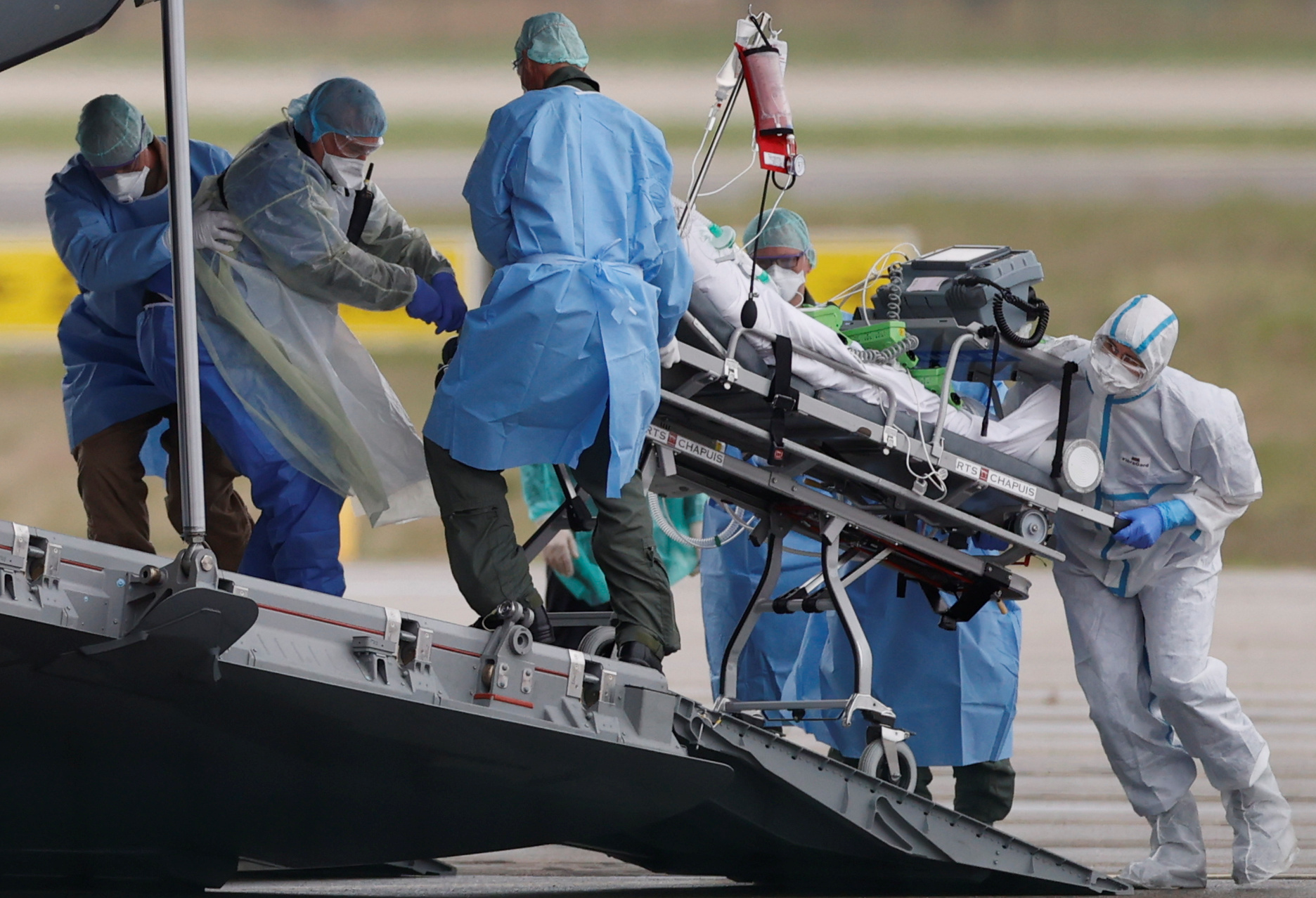 A patient, infected with coronavirus disease (COVID-19), is carried on a stretcher into a German military A400M aircraft during a transfer operation from Strasbourg to Ulm in Germany, France March 29, 2020. REUTERS