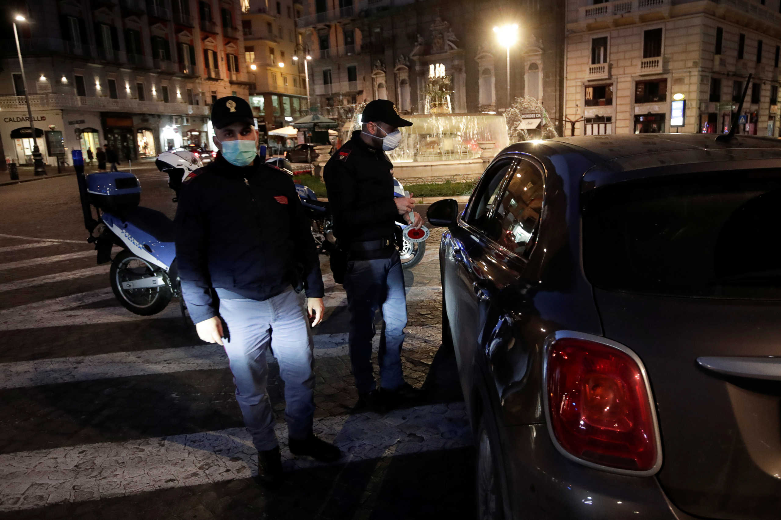Police officers wear protective face masks at a checkpoint on the second day of an unprecedented lockdown across all of the country, imposed to slow the outbreak of coronavirus, in Naples, Italy March 11, 2020. REUTERS