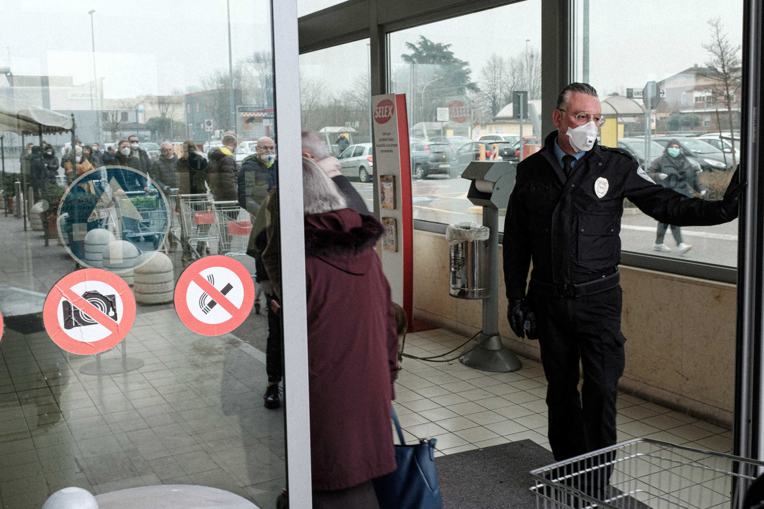 Life inside a red zone: A security guard wearing a protective mask stands at the entrance of a large supermarket in Codogno, one of the towns on lockdown due to coronavirus outbreak, as a long line of residents queue with trollies waiting to enter, in this picture taken by schoolteacher Marzio Toniolo in Codogno, Italy, February 25, 2020. Picture taken February 25, 2020. Marzio Toniolo