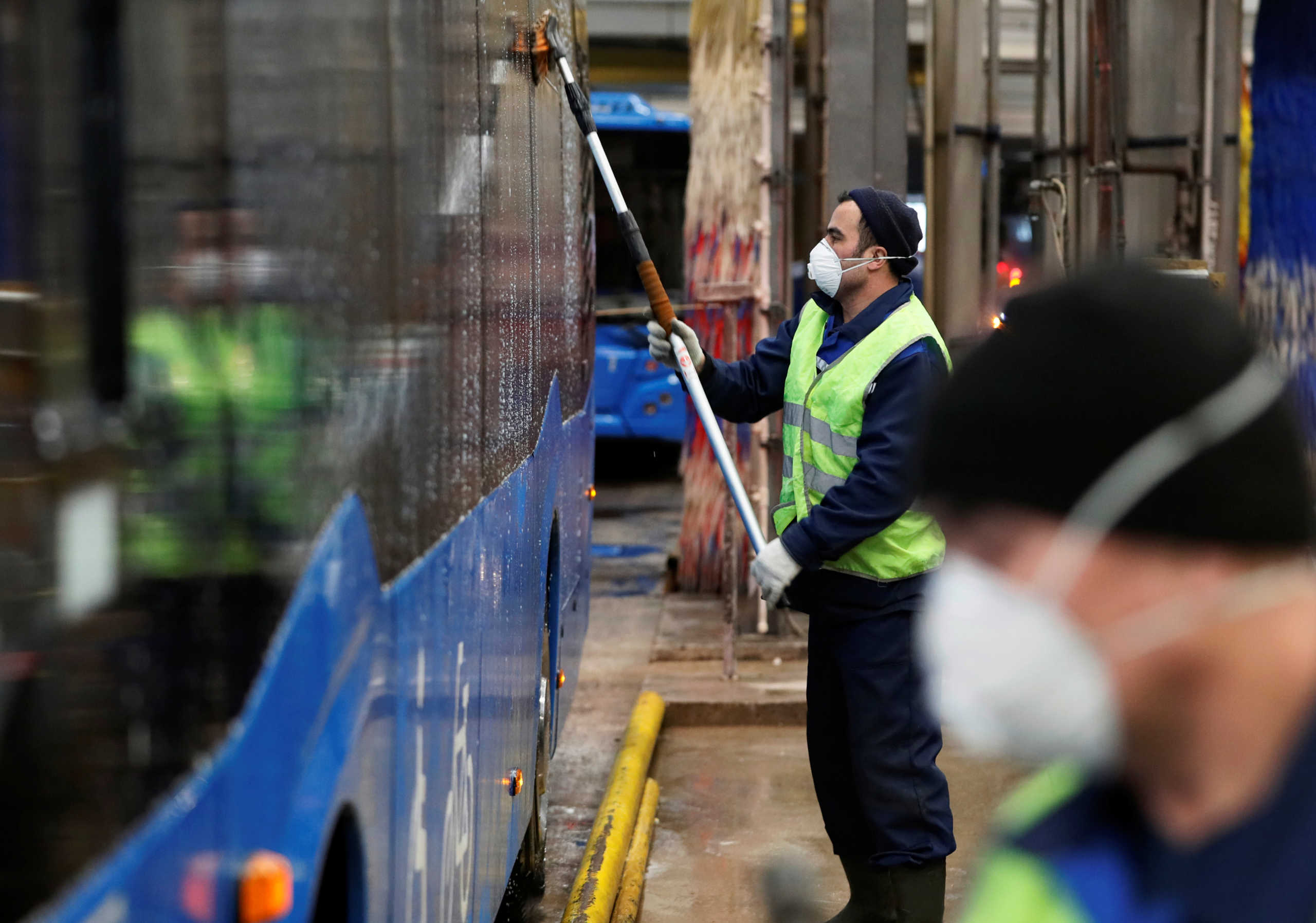 Employees wearing protective face masks clean and disinfect a bus, as part of measures to prevent the potential spread of coronavirus (COVID-19) in Moscow, Russia March 13, 2020. REUTERS