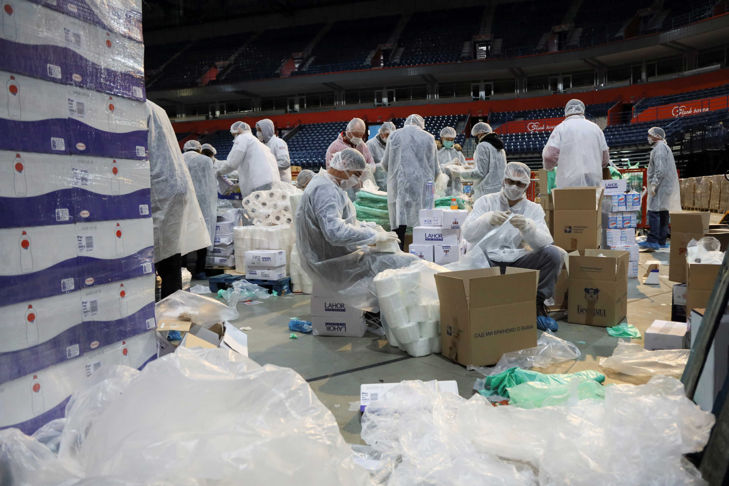 Volunteers help pack boxes of donated aid for elderly people who are banned from leaving their homes because of the coronavirus disease (COVID-19) epidemic in Belgrade, Serbia, March 26, 2020. REUTERS