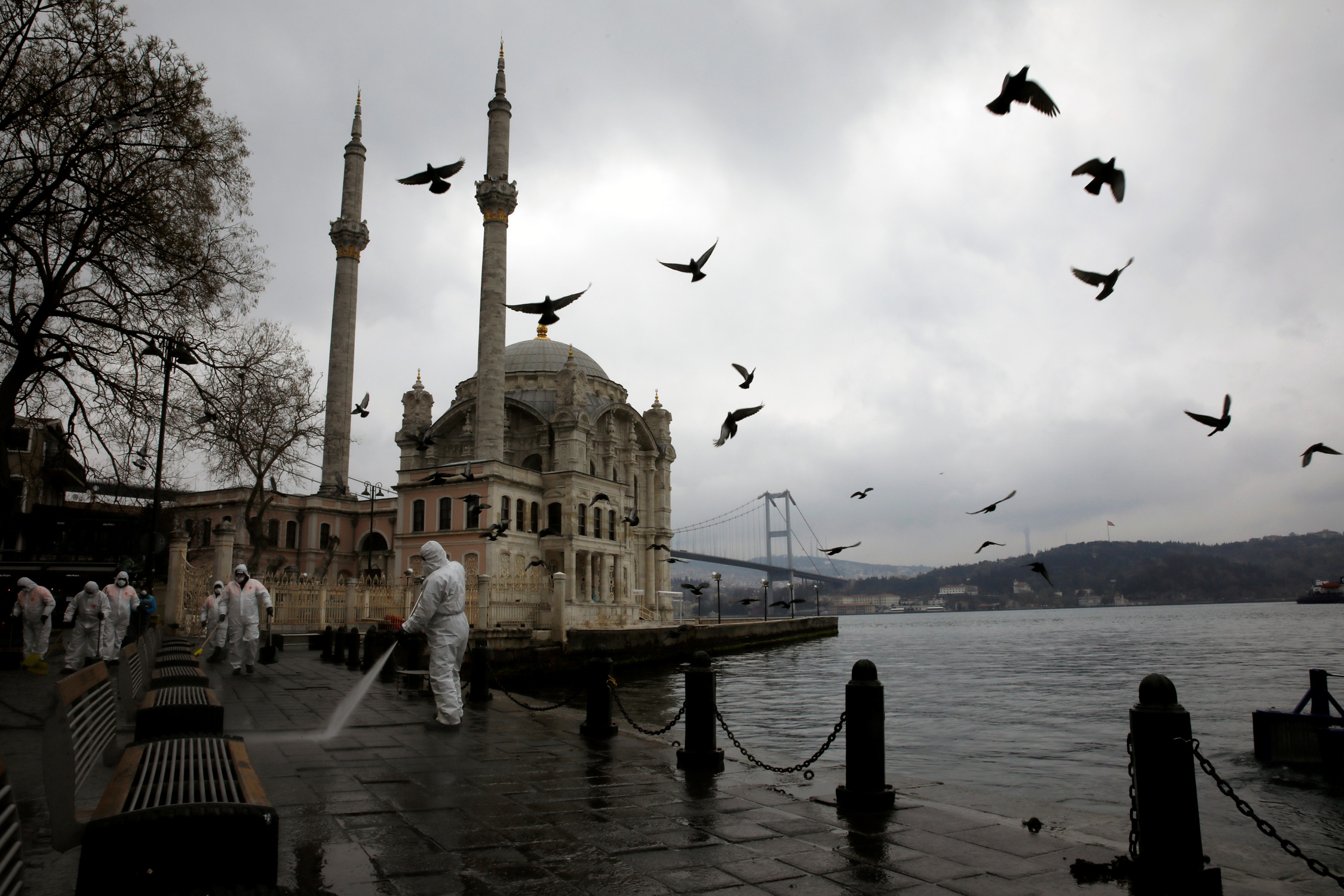 A worker sprays disinfectant outside Ortakoy Mosque, to prevent the spread of coronavirus disease (COVID-19), in Istanbul, Turkey, March 23, 2020. REUTERS