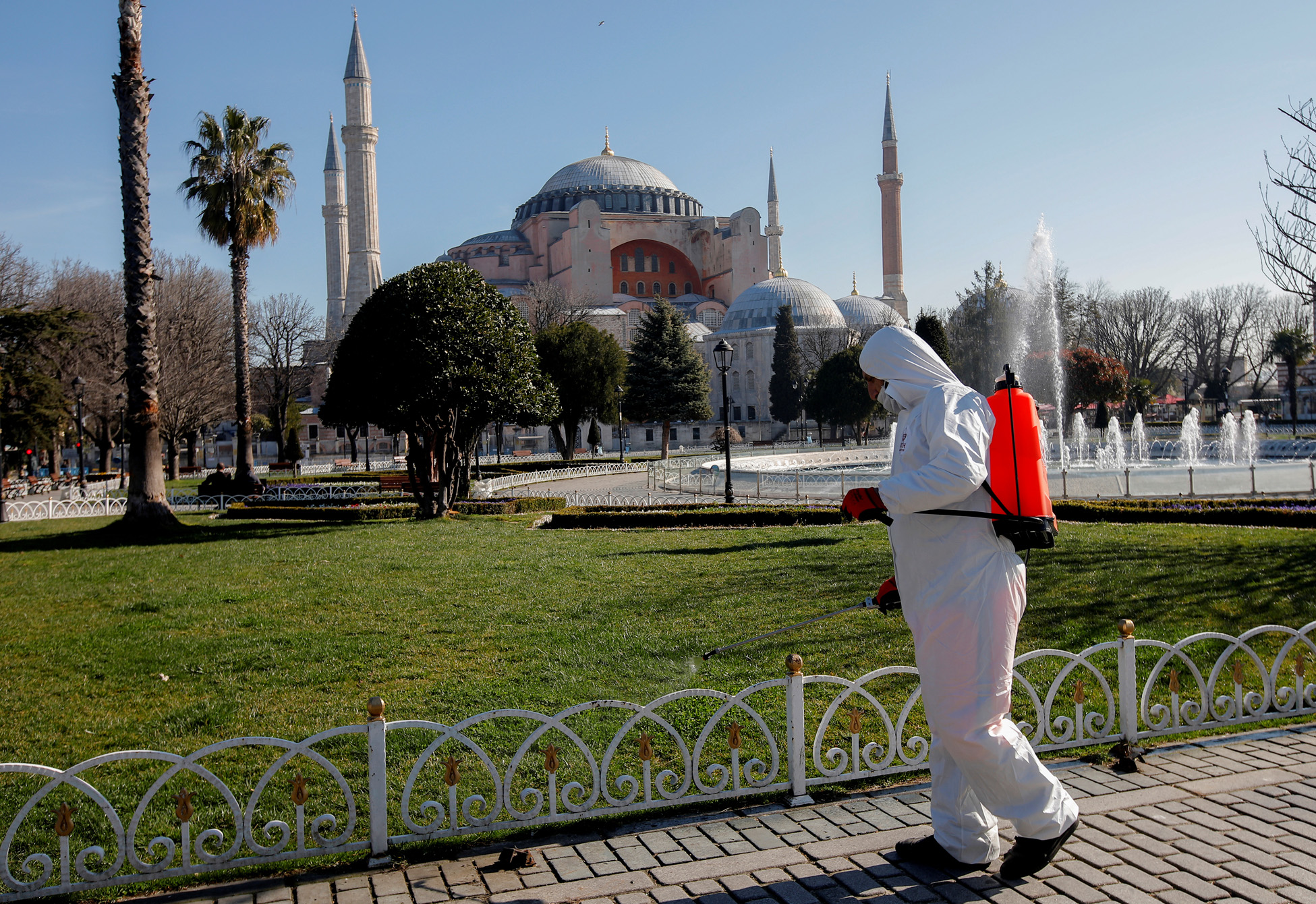 A worker in protective suit disinfects Sultanahmet square in response to the spread of coronavirus disease (COVID-19) in Istanbul,Turkey March 21, 2020. Byzantine-era monument of Hagia Sophia is seen in the background. REUTERS