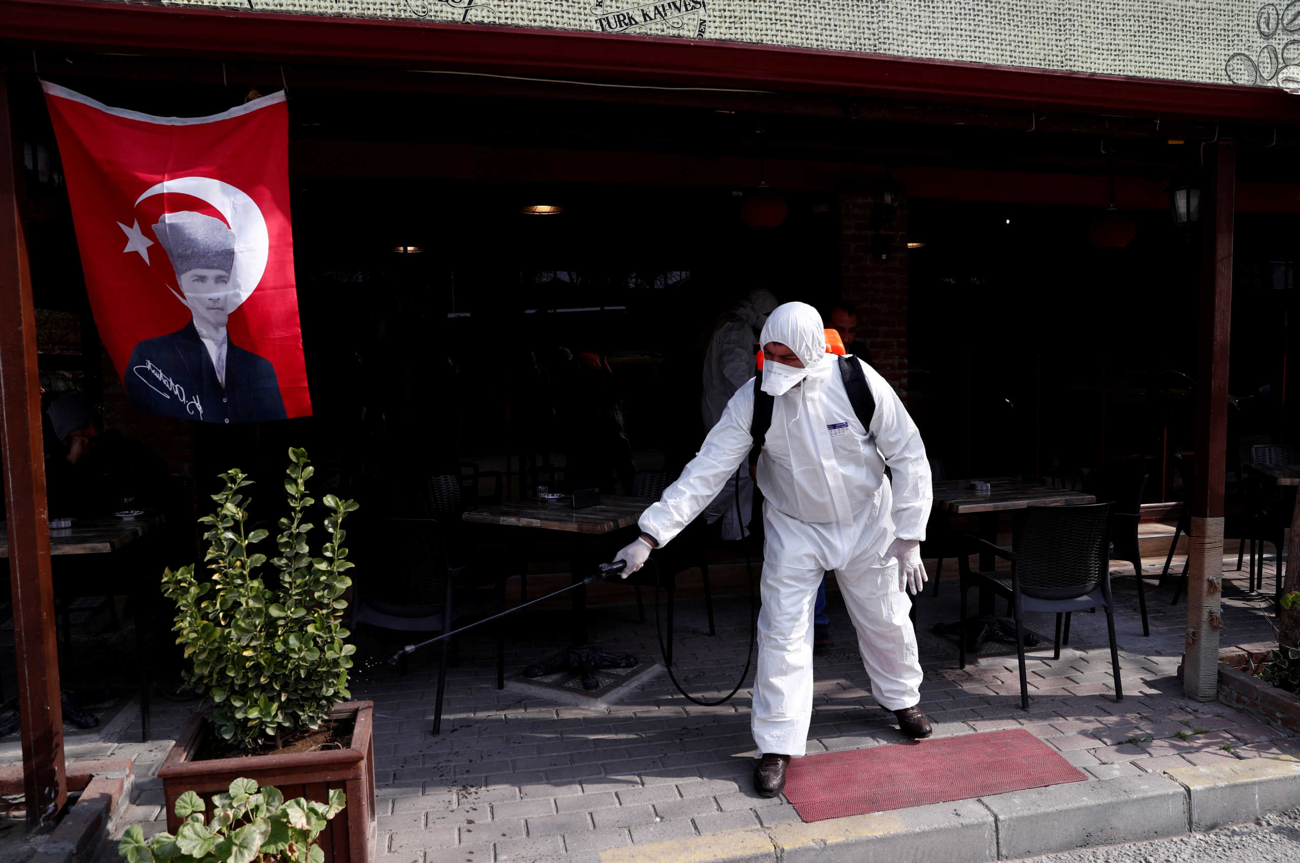FILE PHOTO: A municipality worker wearing protective suit sanitises a coffee shop in Karaagac district against the coronavirus disease (COVID-19) near Turkey's Pazarkule border crossing with Greece's Kastanies, in Edirne, Turkey, March 10, 2020. REUTERS