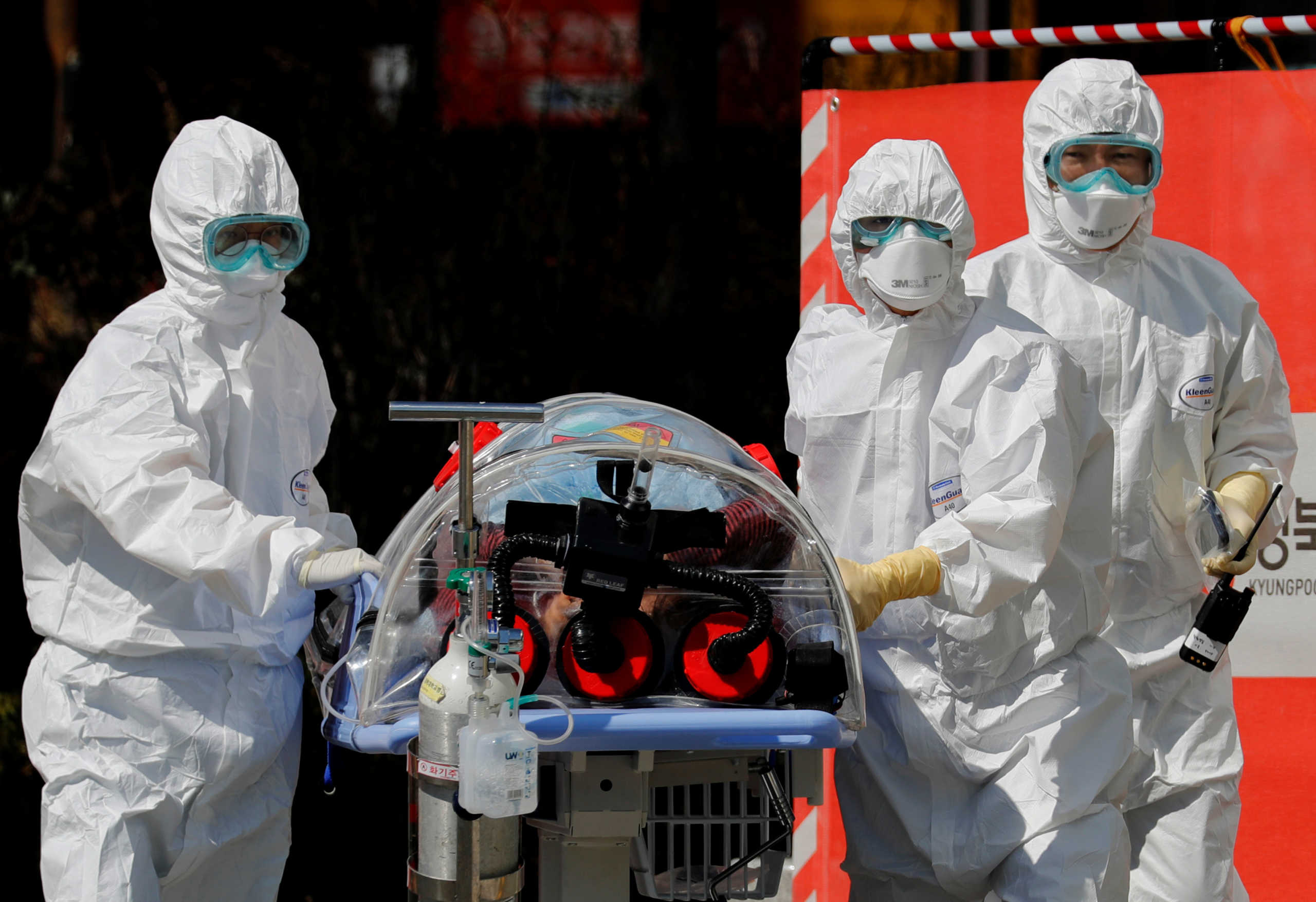 Medical workers carry a patient who is suspected of having coronavirus disease (COVID-19) in a Negative Pressure Isolation stretcher into a facility of Kyungpook National University Hospital in Daegu, South Korea, March 6, 2020. REUTERS