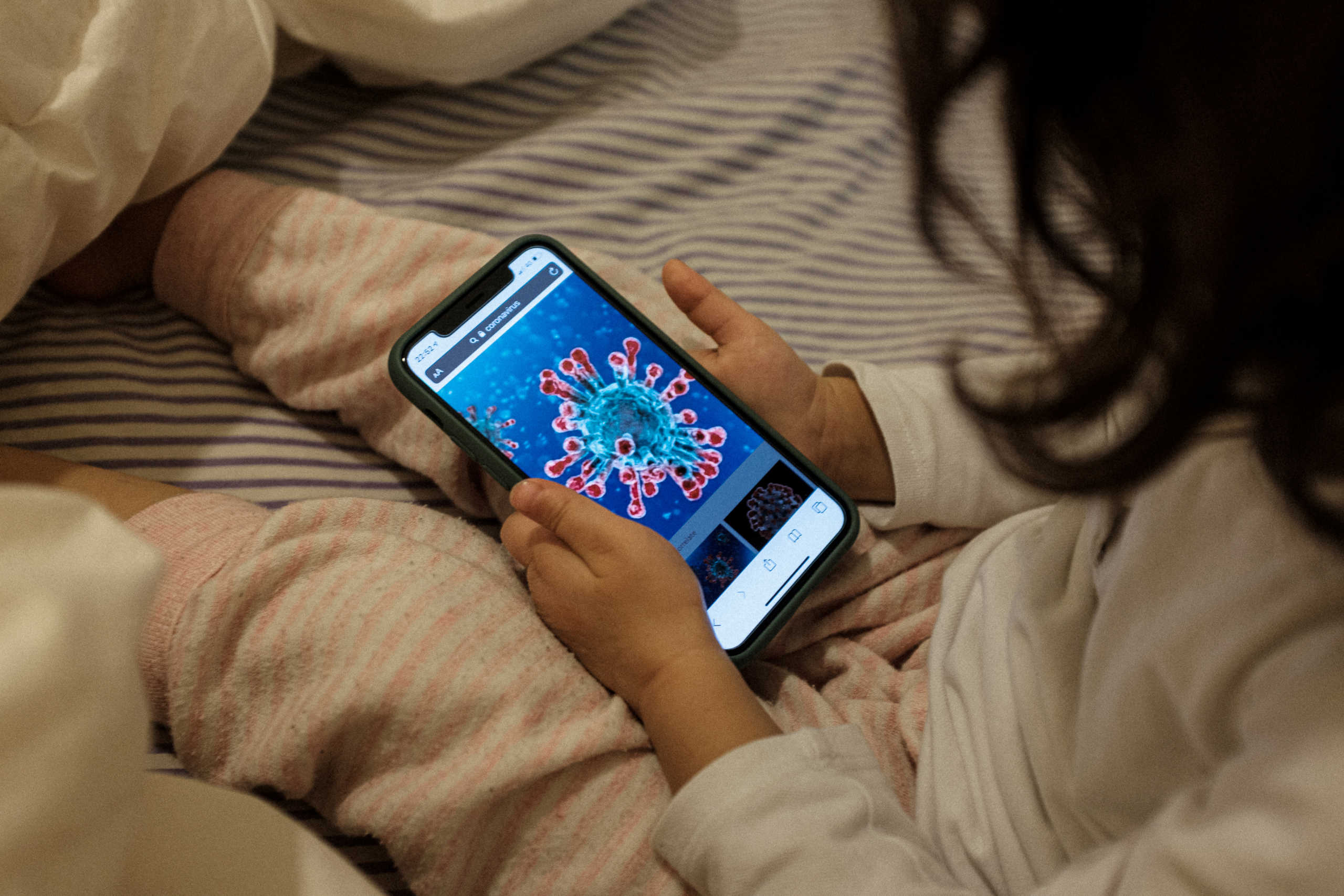 Life inside a red zone: 2-year-old Bianca Toniolo looks on a phone at an illustration of a microscopic view of the new coronavirus, which she says looks like the sun,  at home on a rainy day in San Fiorano, one of the towns in northern Italy on lockdown due to a coronavirus outbreak, in this picture taken by her father Marzio, March 2, 2020. Picture taken March 2, 2020. Marzio Toniolo