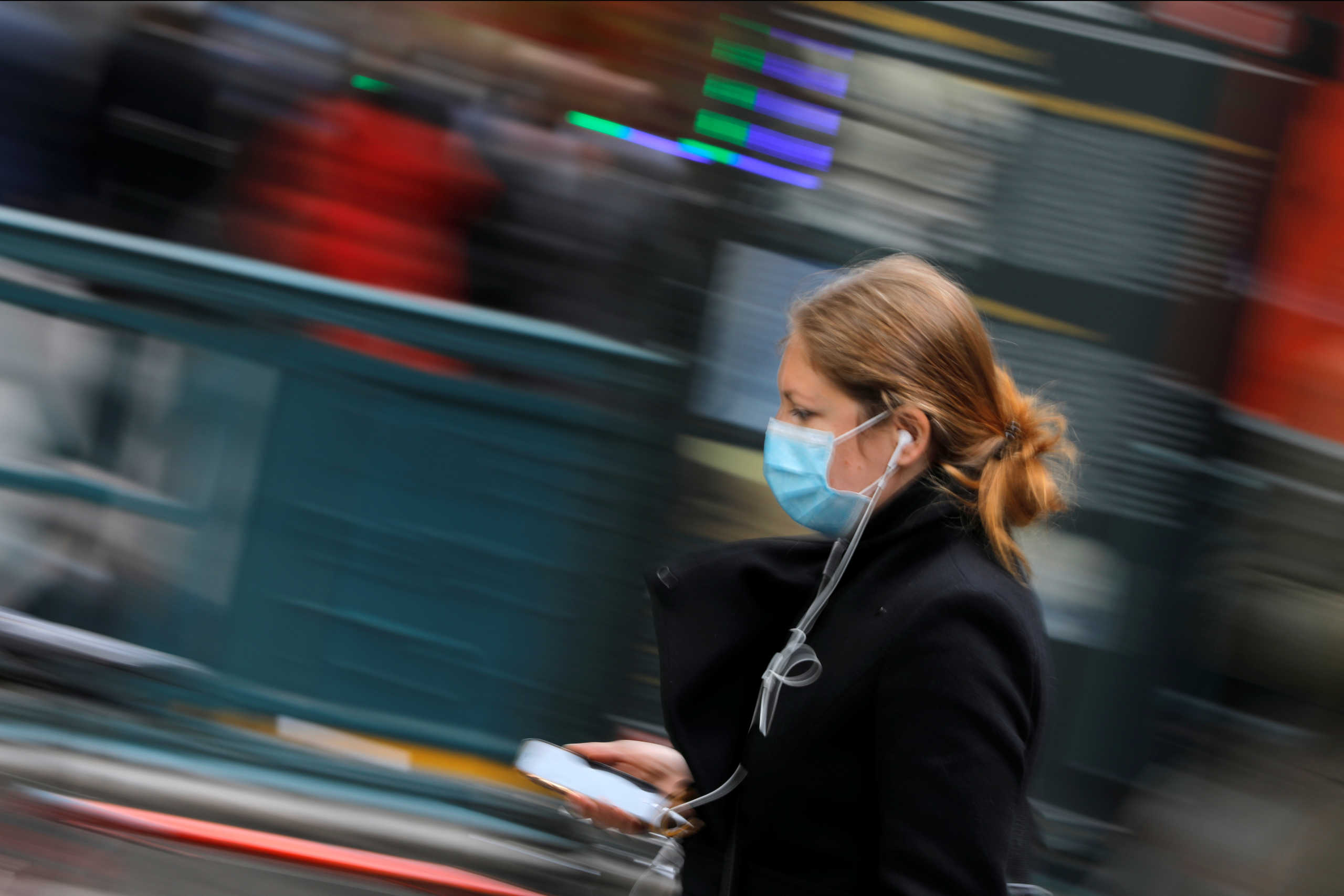 A woman in a face mask walks in the downtown area of Manhattan, New York City, after further cases of coronavirus were confirmed in New York, U.S., March 5, 2020. REUTERS