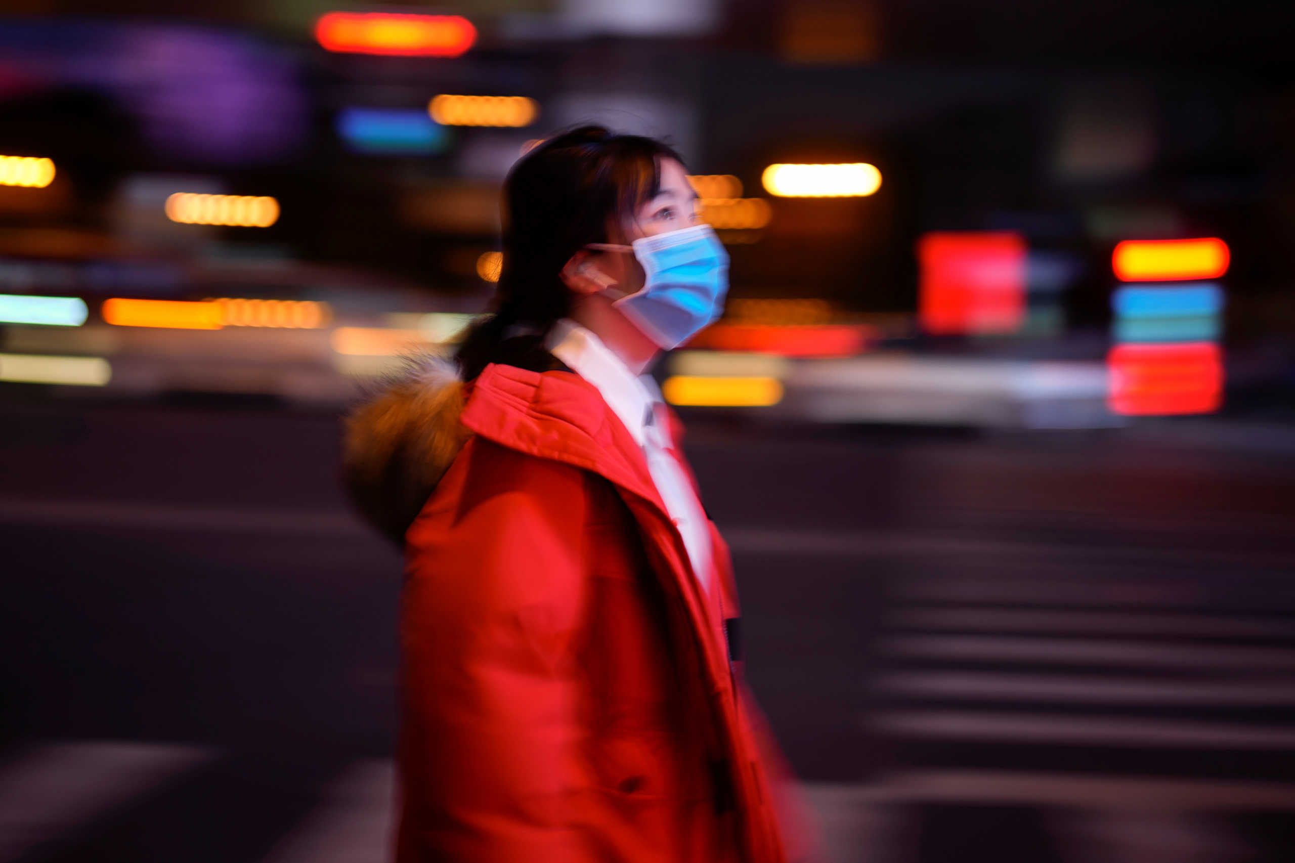 A woman wearing a protective face mask is seen on a crossroad following the outbreak of coronavirus disease (COVID-19), in downtown Shanghai, China March 17, 2020. REUTERS