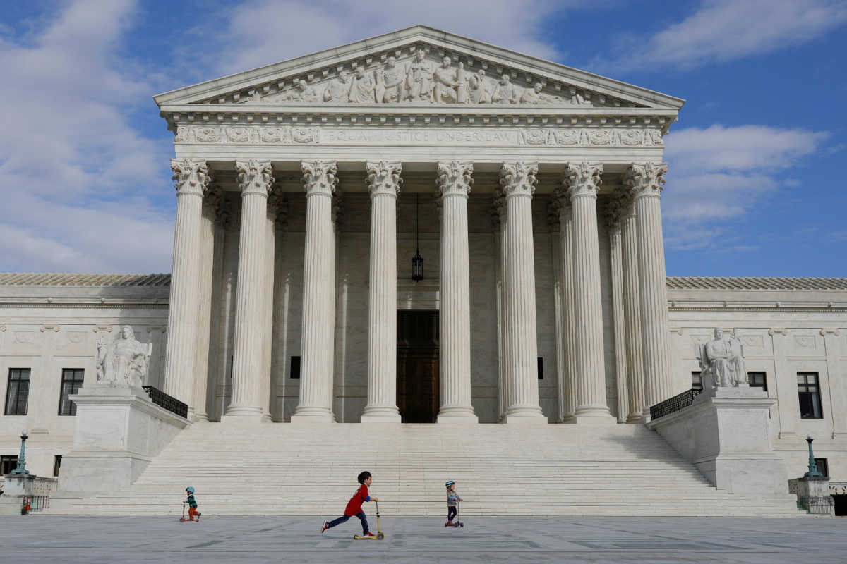 Children ride scooters across the plaza at the United States Supreme Court, following the government's notice to halt all building tours due to the (COVID-19) coronavirus, on Capitol Hill in Washington, U.S., March 17, 2020. REUTERS