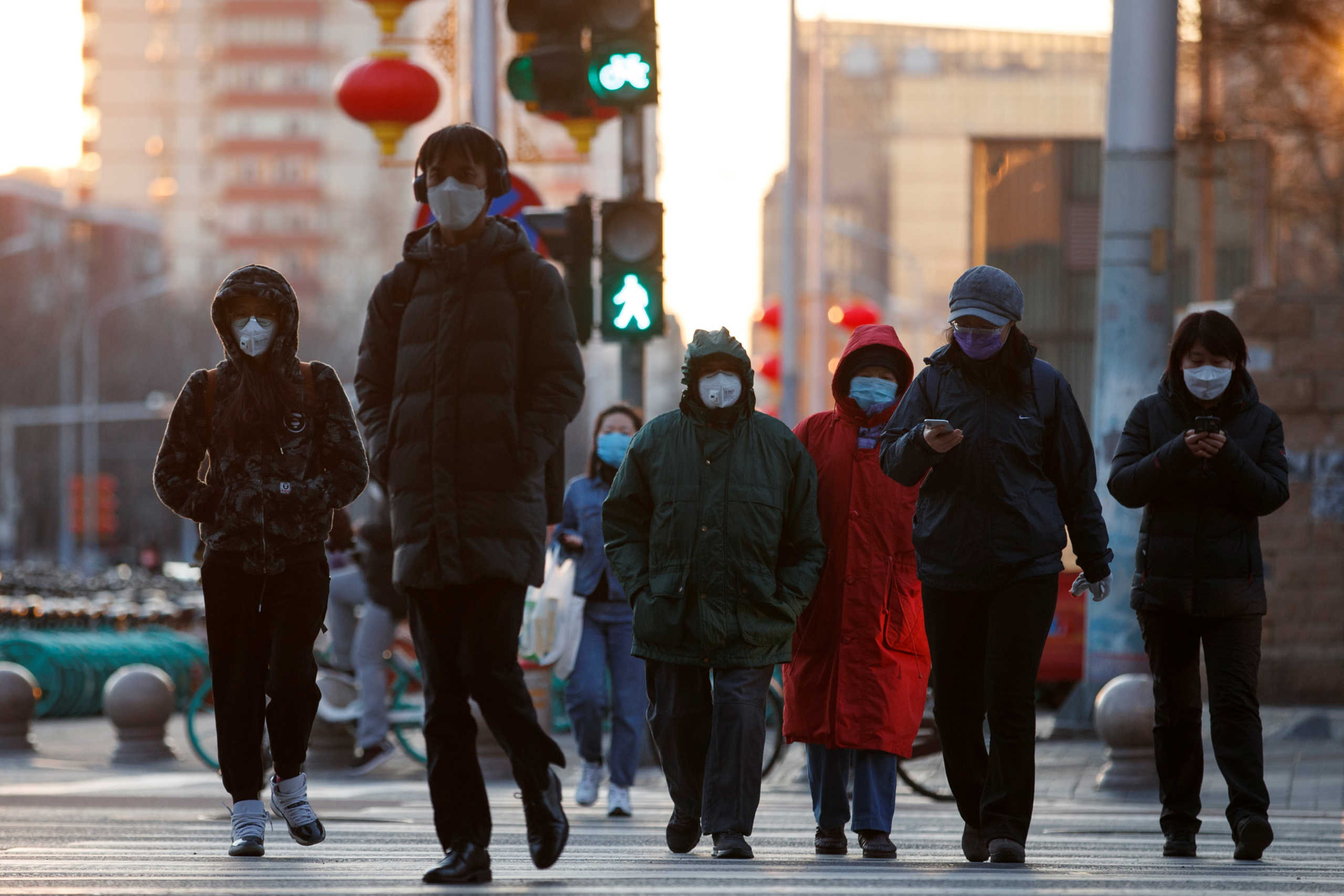 People wear masks as they cross a street during evening rush hour, as the country is hit by an outbreak of the novel coronavirus, in Beijing, China, March 3, 2020. REUTERS