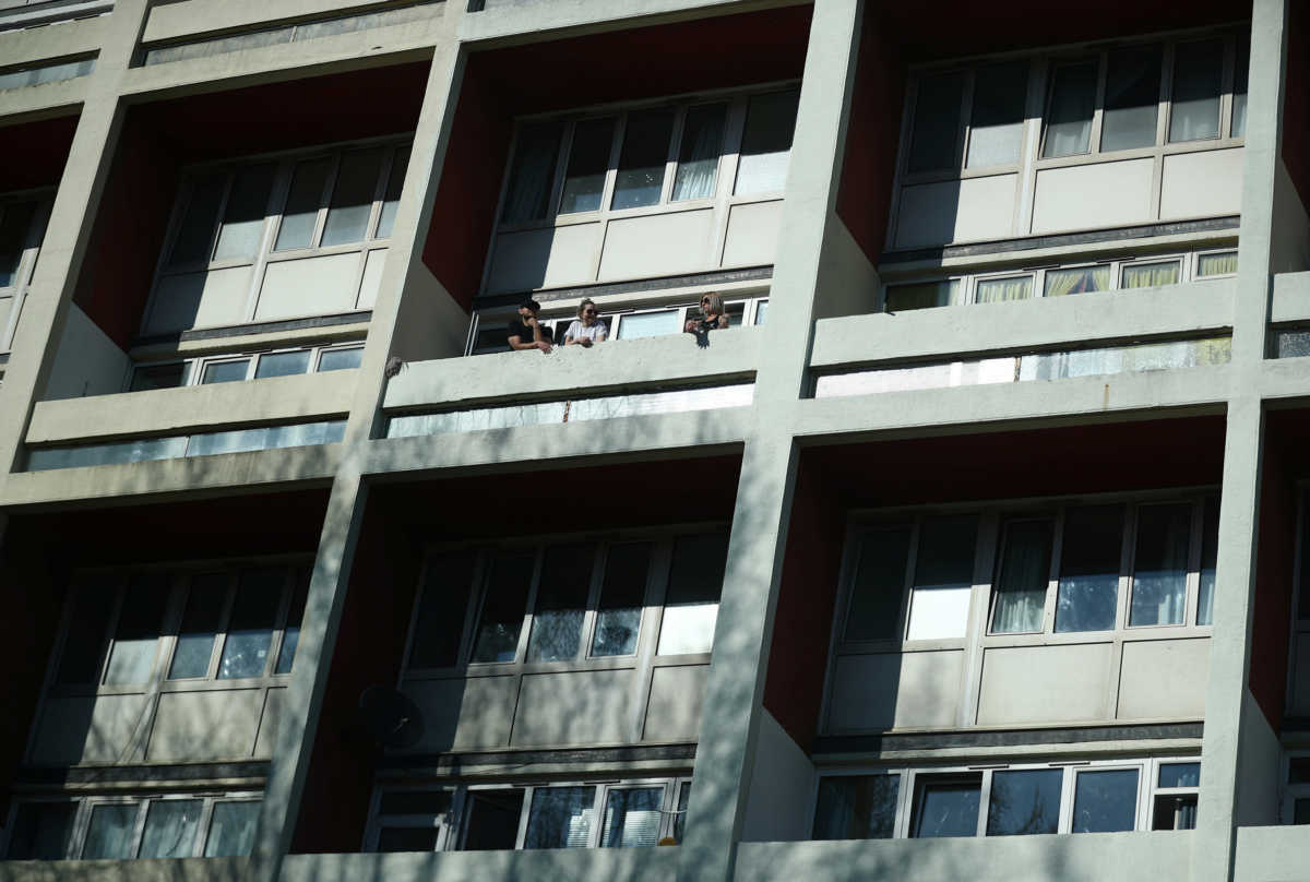 People on their balcony in Canterbury house, as the spread of the coronavirus disease (COVID-19) continues, in London, Britain, March 25, 2020. REUTERS