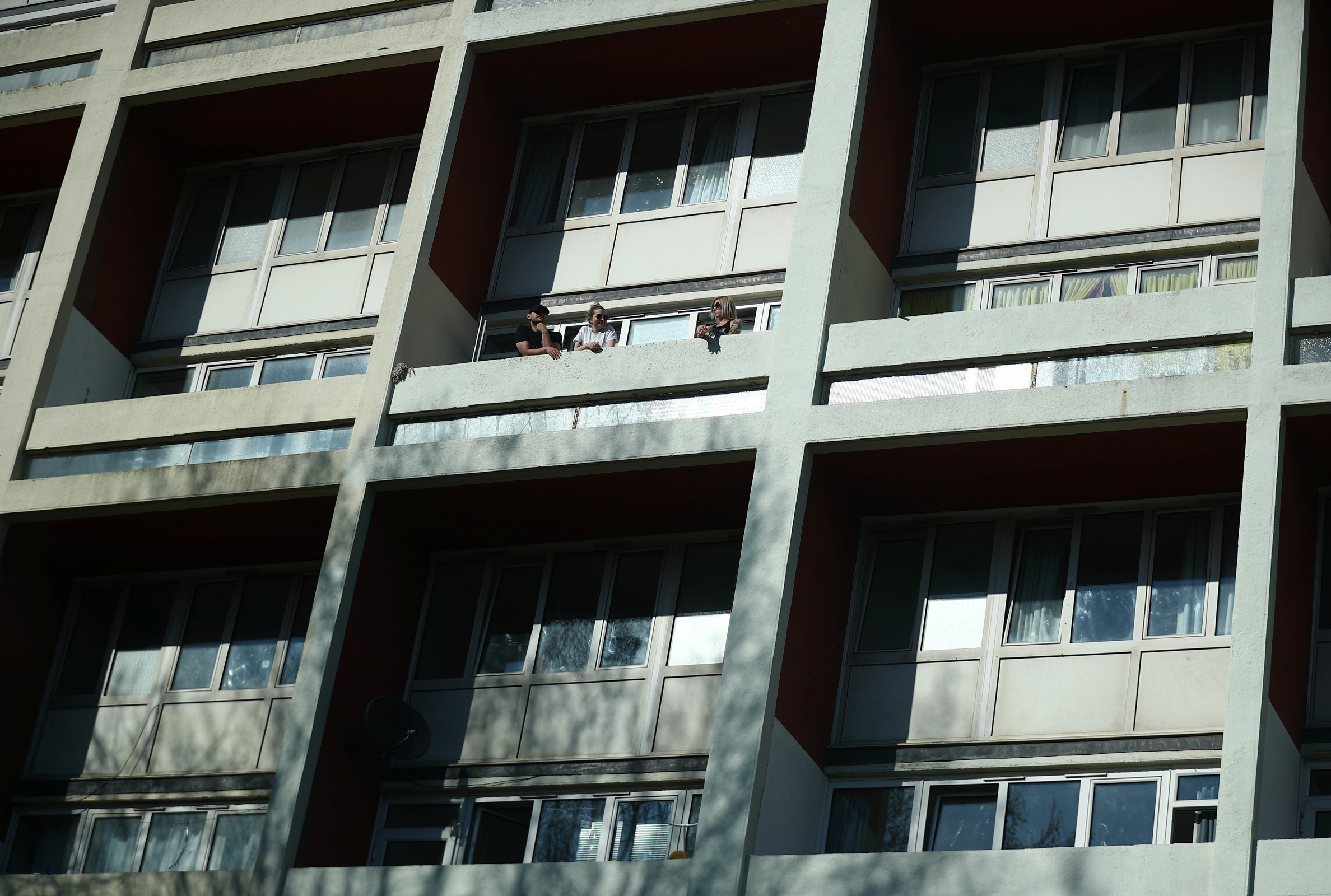 People on their balcony in Canterbury house, as the spread of the coronavirus disease (COVID-19) continues, in London, Britain, March 25, 2020. REUTERS