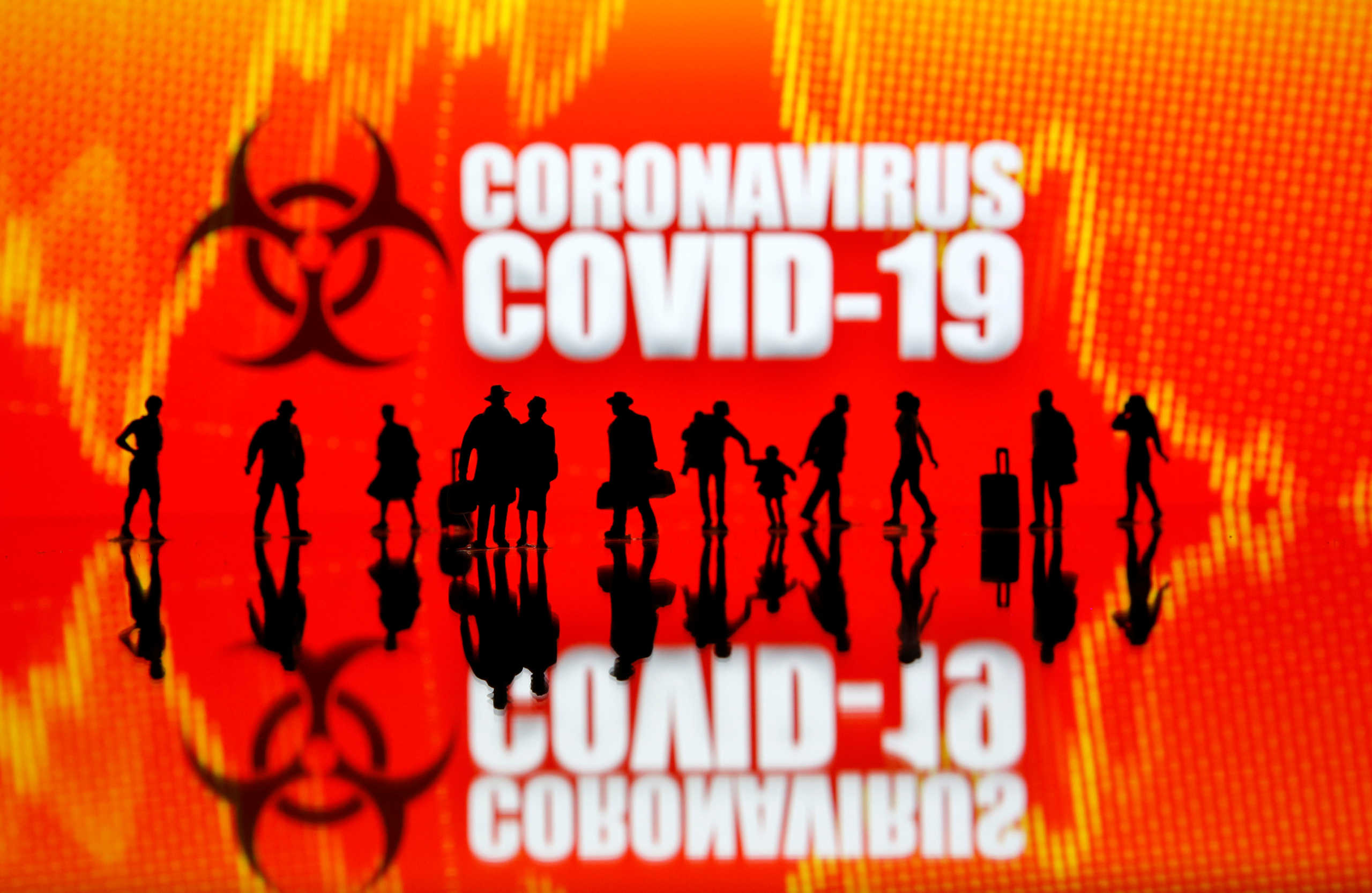 Small toy figures are seen in front of the coronavirus (COVID-19) sign in this illustration taken March 12, 2020. REUTERS