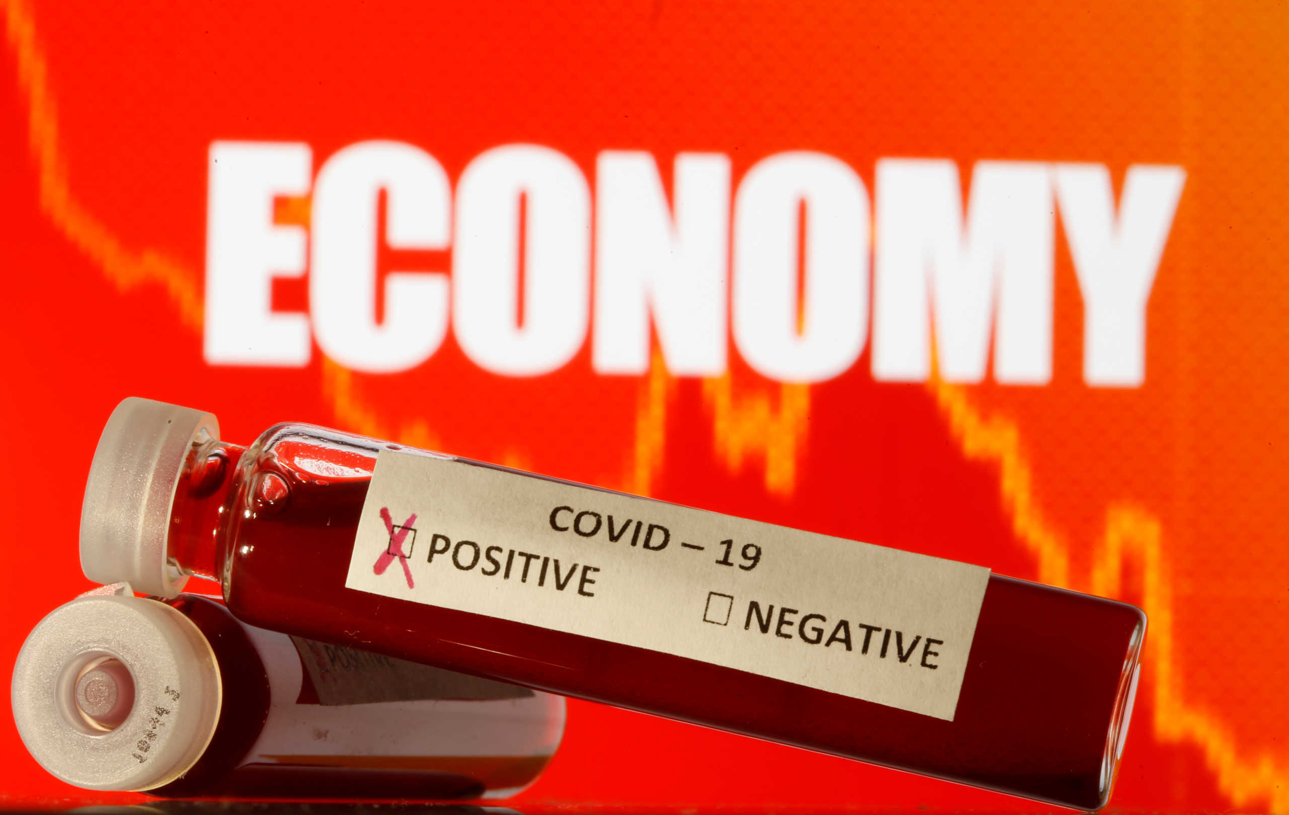 Fake blood is seen in test tubes labelled with the coronavirus (COVID-19) in front of the word "Economy" in this illustration taken March 11, 2020. REUTERS